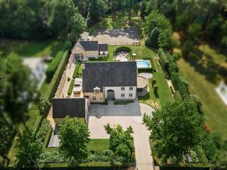 <p><strong>Exclusieve villa met tweede woonentiteit, paardenaccommodatie en infinity pool aan Rinkven Golf</strong></p>
<p><strong>Uitzonderlijk gerenoveerde villa met multifunctioneel bijgebouw, paardenaccommodatie, verwarmd infinityzwembad en schitterende uitrijmogelijkheden, gelegen op een uniek perceel van ca. 5.000 m² aan de golf van Rinkven in Sint-Job-in-'t-Goor.</strong></p>
<p>Op een absolute toplocatie, rechtstreeks grenzend aan de prestigieuze golf van Rinkven, bevindt zich deze royale en energiezuinige villa met een uitzonderlijk aanbod aan woon- en ontspanningsfaciliteiten. Het geheel omvat naast de hoogwaardig afgewerkte hoofdwoning ook een volwaardige tweede woonentiteit – momenteel ingericht als schoonheidssalon – een verwarmd infinityzwembad, paardenstallen en een rijbak met uitstekende uitrijmogelijkheden.</p>
<p>De villa werd oorspronkelijk gebouwd in 2000 en in 2020 volledig en bijzonder grondig gerenoveerd. Daarbij werd niet alleen aandacht besteed aan esthetiek en wooncomfort, maar eveneens aan energiezuinigheid, hedendaagse technieken en hoogwaardige afwerking.<br /><br /></p>
<p><strong>Hoofdwoning</strong></p>
<p><strong>Gelijkvloers</strong></p>
<p>De royale inkomhal vormt een stijlvolle entree en geeft toegang tot de verschillende leefruimtes en de verdieping. Hier bevinden zich tevens een vestiaire, gastentoilet en afzonderlijk bureel.</p>
<p>De bijzonder ruime leefruimte is ingedeeld in verschillende sfeervolle zones, waaronder een elegante eethoek, een comfortabele zitkamer met doorkijk-gashaard en een uitnodigende lounge. Grote raampartijen zorgen voor een aangename lichtinval en versterken de verbinding met de omliggende tuin en het unieke uitzicht.</p>
<p>De luxueuze maatwerkkeuken is uitgerust met hoogwaardige apparatuur en beschikt over een strak en eigentijds ontwerp met geïntegreerde, vrijwel onzichtbare kookpitten.</p>
<p>Verder omvat het gelijkvloers een praktische wasplaats en koele berging, evenals toegang tot de ruime dubbele inpandige garage. De verdieping van de garage is momenteel ingericht als gameroom/fitnessruimte en biedt tal van mogelijkheden voor verdere invulling.</p>
<p><strong>Eerste verdieping</strong></p>
<p>De eerste verdieping beschikt over drie ruime slaapkamers, waarvan momenteel één kamer stijlvol is ingericht als dressing.</p>
<p>Er is een aparte badkamer met douche en maatwerkmeubel.</p>
<p>De royale master suite vormt een volwaardige privéverdieping binnen de woning en beschikt over een ruime dressing en een luxueuze badkamer, uitgerust met een ruime inloopdouche en ligbad.</p>
<p><strong>Zolderverdieping</strong></p>
<p>Via een vaste trap is de ruime zolder bereikbaar. Dankzij de beschikbare oppervlakte en indeling kunnen hier relatief eenvoudig nog <strong>twee bijkomende slaapkamers en een badkamer</strong> worden gerealiseerd.<br /><br /></p>
<p><strong>Multifunctioneel bijgebouw – volwaardige tweede woonentiteit</strong></p>
<p>Het bijgebouw is momenteel ingericht als schoonheidssalon, maar heeft dankzij zijn volwaardige voorzieningen en zelfstandige indeling eveneens de potentie om als tweede woning, gastenverblijf, kantoor of praktijkruimte te worden gebruikt.</p>
<p>Deze tweede woonentiteit maakt het eigendom bijzonder veelzijdig en biedt interessante mogelijkheden voor <strong>dubbele bewoning, inwonende familie, gasten, een zelfstandige activiteit of professionele doeleinden</strong>.</p>
<p><strong>Buitenbeleving & paardenaccommodatie</strong></p>
<p>De tuin is ingericht rond een <strong>verwarmd infinityzwembad met overlooprand en buitendouche</strong>, waardoor een bijzonder aangename vakantiesfeer ontstaat.</p>
<p>Voor paardenliefhebbers is de eigendom uitgerust met <strong>paardenstallen en een rijbak</strong>, gecombineerd met uitstekende mogelijkheden om rechtstreeks vanuit het perceel uit te rijden.</p>
<p>De ligging aan de golf van Rinkven vormt bovendien een uniek decor en zorgt voor een bijzonder open en groen karakter.</p>