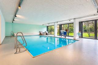 <p><strong><span>Villa-appartement met privatieve stadstuin en eigen wellnessruimte</span></strong></p>
<p><span>Thuiskomen in alle rust, op een steenworp van het stadsleven: dat is de bijzondere combinatie die dit villa-appartement biedt. Het ligt in een residentiële buurt nabij Brouwerij De Koninck, het Koning Albertpark en het Harmoniepark, met winkels, openbaar vervoer en belangrijke invalswegen vlakbij.</span></p>
<p><span>De stijlvolle inkomhal, met vestiaire en gastentoilet, leidt naar een royale leefruimte met parketvloer en open haard. Dankzij de uitzonderlijke gevelbreedte en de grote ramen krijgt de ruimte volop licht en kijkt u uit op de privatieve stadstuin. Er is plaats voor een ruime eettafel, verschillende zithoeken en een bureauhoek ,die naar wens kunnen worden ingericht.</span></p>
<p><span>Ook de keuken nodigt uit om samen te komen. Rond het kookeiland met inox werkblad is er ruimte om te koken en bij te praten; in de ontbijthoek begint u rustig aan de dag. De keuken beschikt over veel opbergruimte en Smeg-toestellen, waaronder een vijfpitsgasfornuis, grill, friteuse, oven, stoomoven, microgolfoven, vaatwasser, koelkast en diepvries.</span></p>
<p><span>Via de nachthal bereikt u drie ruime slaapkamers op parket. De masterbedroom heeft een ensuite walk-in dressing en een badkamer met ligbad, inloopregendouche en dubbele wastafel. De twee andere slaapkamers delen een tweede badkamer met inloopregendouche, wastafel en toilet.</span></p>
<p><span>De grootste verrassing wacht op een ander niveau, bereikbaar met de privatieve lift: een inpandige wellnessruimte met binnenzwembad, sauna, stoomcabine, fitnessruimte, inloopregendouche en afzonderlijk toilet. De schuiframen naar de tuin kunnen volledig open, zodat de wellnessruimte en het groen met elkaar verbonden worden. Wie een andere invulling voor deze ruimte voor ogen heeft, vindt hier bovendien bijzondere mogelijkheden.</span></p>
<p><span>Dit uitzonderlijke villa-appartement combineert een prestigieuze ligging met hoogwaardige afwerking en een luxueuze woonbeleving, perfect voor wie comfort en exclusiviteit zoekt in het hart van de stad.<br /><br />Een inpandige garage met automatische poort biedt plaats aan twee grote wagens en extra bergruimte.</span></p>
<p><strong><span>Een thuis met de ruimte van een villa, de privacy van een stadstuin en een plek om helemaal tot rust te komen.</span></strong>.</p>
<br /><span><strong>BIJZONDERHEDEN; </strong></span><br />* Uitzonderlijk villa-appartement met magnifieke privatieve tuin<br />* Uitstekende EPC; 166kWh/m², conforme keuring, asbestvrij<br />* Uitzonderlijke gevelbreedte van 17,26m <br />* Grote inpandige garage, kelder, verwarmd binnenzwembad 11m x 5m<br />* Gebouw voorzien van een nieuw dak met isolatie (2024-2025), lift conform, veiligheidsdeur