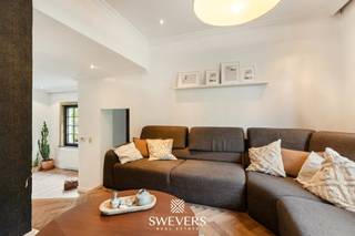 Voor meer info en foto’s, surf naar www.swevers.be – In de Koolmijnlaan 285 te Heusden-Zolder ontdek je deze charmante halfopen woning met rijke geschiedenis, gebouwd in 1924. De gevel met cederhouten accenten en acaciahouten voordeur straalt warmte uit, terwijl tal van vernieuwingen zorgen voor hedendaags comfort. Zo werd het dak vernieuwd in 2008, de gevel en ramen aangepakt in 2019 en kreeg de verwarmingsketel in 2024 nog een nieuwe brander. Binnen geniet je van een gezellige leefruimte met authentieke elementen zoals houten vloeren en sierlijsten. De keuken van 13 m² met veranda biedt veel licht en een prachtig zicht op de tuin. Verder zijn er een badkamer, wasplaats en inpandige garage van 17,66 m² aanwezig. Het perceel van 4a 88ca is volledig omheind, mooi aangeplant en geniet van een noordoostelijke oriëntatie met privacy en ochtendzon. Boven zijn er drie slaapkamers (13,38 m² – 13,83 m² – 7,65 m²) en een ruime zolder van 35,17 m² met uitbreidingsmogelijkheden. Extra troeven zijn de droge kelder van 11,85 m² en de vlotte bereikbaarheid dankzij de nabijheid van winkels, scholen en de E314. Deze woning combineert charme, authenticiteit en een zonnige tuin in een bruisende buurt – ideaal voor gezinnen die op zoek zijn naar karakter en comfort. Voor meer informatie, bel 011 255 155. Bron bewoonbare oppervlakte: EPC – verslag.