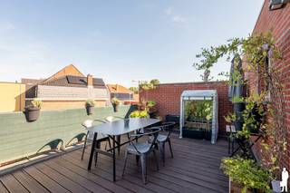<p><strong>Instapklaar appartement met 2 ruime slaapkamers, autostaanplaats, private kelderberging en zonnig terras van ca. 21 m² op wandelafstand van het centrum, kunstacademie en hondenweide en fietsafstand van natuurreservaat Het Goorken en Lokkerse dammen, Energielabel B.</strong></p>
<p>Welkom in dit bijzonder ruime en instapklare appartement, waar comfort, licht, een doordachte indeling en een hoogwaardige afwerking mooi samenkomen. Met twee volwaardige slaapkamers, een royaal zuidwestgericht terras, een autostaanplaats én een private berging biedt deze woning alles wat u nodig heeft voor aangenaam en zorgeloos wonen.</p>
<p>Via de gemeenschappelijke inkomhal, afgewerkt met een prachtige natuurstenen bevloering, bereikt u dit duplexappartement op de eerste verdieping. Zodra u binnenstapt, vallen meteen de royale woonoppervlakte en het aangename ruimtegevoel op. De verschillende leefruimtes sluiten mooi op elkaar aan en werden praktisch en stijlvol ingericht. De ruime inkomhal biedt voldoende plaats voor een vestiaire en vormt het centrale punt van het appartement. Van hieruit heeft u enerzijds toegang tot de leefruimtes en anderzijds tot de slaapvertrekken op de tweede verdieping. De lichtrijke woonkamer vormt het hart van de woning en geniet dankzij de grote raampartijen van een overvloed aan natuurlijk daglicht. De leefruimte werd opgedeeld in een gezellige zithoek aan de straatzijde en een royale eethoek aansluitend bij de keuken. Hierdoor ontstaat een aangename en open leefomgeving waar zowel ontspannen als uitgebreid tafelen perfect tot zijn recht komt. De keuken werd volledig op maat uitgewerkt en combineert een stijlvolle uitstraling met optimaal gebruiksgemak. Er is ruim voldoende werk- en opbergruimte en uiteraard zijn alle nodige toestellen aanwezig. Een leuke extra is de gezellige ontbijthoek met hoge tafel: de ideale plek voor een snelle koffie in de ochtend, een informele lunch of een aperitief met familie en vrienden. Vanuit de keuken heeft u rechtstreeks toegang tot één van de absolute blikvangers van het appartement: het zuidwest georiënteerde terras van circa 21 m². Dankzij de gunstige oriëntatie geniet u hier volop van de middag- en avondzon. Het terras is mooi afgewerkt, biedt verrassend veel privacy en kijkt aangenaam uit over het omliggende groen. Wanneer de avond valt, krijgt u bovendien een sfeervol uitzicht op de verlichte Toremansmolen. Een heerlijke buitenruimte waar u in alle rust kunt zonnen, aperitieven, tafelen of simpelweg ontspannen na een lange dag.</p>
<p>Op de verdieping bevinden zich twee ruime en volwaardige slaapkamers, waardoor het appartement perfect geschikt is voor een koppel, een klein gezin of wie graag beschikt over een extra bureau-, hobby- of logeerkamer. Verder beschikt de woning over een praktische bergruimte, twee afzonderlijke toiletten en een verzorgde, stijlvolle badkamer. Deze is uitgerust met een ligbad met douchefunctie, twee wastafels, een ruime spiegelkast en praktische onderkasten. Ook hier werd veel aandacht besteed aan comfort en voldoende opbergruimte.</p>
<p>Als extra troef zijn zowel de autostaanplaats als de private berging inbegrepen. U beschikt dus niet alleen over een vaste parkeerplaats, maar ook over bijkomende opslagruimte voor bijvoorbeeld fietsen, seizoensmateriaal of andere persoonlijke spullen.</p>
<p>Kortom, dit is een ruim, lichtrijk en volledig instapklaar appartement dat zich onderscheidt door zijn aangename indeling, kwalitatieve afwerking en bijzonder fijn terras. De combinatie van twee ruime slaapkamers, een grote buitenruimte, een eigen autostaanplaats en private berging maakt dit tot een zeer complete woonst waar u zonder zorgen meteen uw intrek kunt nemen.</p>
<p></p>