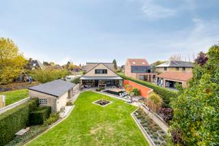 <p><strong><em>Zeer ruime villa (2002 - 415 m²) met 5 kamers, 2 badkamers, dressing, garage, kelder met ontspanningsruimte, terras met pergola en een mooi aangelegde tuin met sier/zwemvijver en tuinberging op een perceel van 18a 25ca gelegen op een landelijke en rustige omgeving te Lubbeek.</em></strong><br /><strong><em>Deze villa is ook uitermate geschikt als kangoeroewoning of mogelijkheden voor vrij beroep.</em></strong><br /><strong><em>Ideaal voor wie houdt van klasse, maar ook van warmte en gezelligheid.</em></strong> </p><p>De inkomhal verwelkomt je met ingebouwde vestiaire en gastentoilet. Gelijkvloers bevindt zich een grote slaapkamer met dressing en eigen badkamer – ideaal voor wie alles op één niveau wil.<br />De lichtrijke woonkamer met inbouwcassette en bar vormt het hart van de woning en biedt een prachtig uitzicht op de tuin en directe toegang tot het terras met pergola.<br />De ruime keuken met eethoek, afgewerkt in natuursteen, straalt luxe uit en is uitgerust met alle comfort. Daarnaast is er een praktische berging/wasplaats. </p><p>Op de verdieping zorgt de hoge nok voor een aangenaam, open gevoel.<br />Via de centrale nachthal bereik je vier mooie slaapkamers, waarvan één momenteel is ingericht als extra keuken – ideaal voor wie een kangoeroewoning overweegt. Verder is er een tweede badkamer en een extra berging. </p><p>De woning is volledig onderkelderd en biedt niet alleen enorm veel bergruimte, maar ook een ingerichte ontspanningsruimte.<br />Er is een inpandige garage met elektrische sectionaalpoort en afgietbak, en aan de voorzijde zijn vier autostaanplaatsen voorzien.</p><p> <strong>Extra troeven</strong> maken van deze woning een bijzonder aanbod:<br />- Energiezuinige woning met EPC-label B (175 kWh/m²/jaar)<br />- Zonnepanelen met groene stroomcertificaten<br />- Regenwaterput van 10.000 liter en waterverzachter<br />- Alarm, surroundsysteem, inbouwspots<br />- Hoogwaardige materialen en een sfeervolle, luxueuze afwerking<br />- Volledig instapklaar, geen asbest en slechts beperkte aanpassingen aan de elektriciteit vereist</p><p>De buitenruimte is al even uitnodigend: een ruim terras met pergola en sier/zwemvijver, omringd door een zorgvuldig aangelegde tuin met tuinberging – een plek waar je in alle rust kan genieten van de landelijke omgeving. </p><p>De ligging combineert rust en bereikbaarheid: op fietsafstand van het centrum van Lubbeek met winkels, scholen, apotheek, bib en sportfaciliteiten, en met uitstekende verbindingen richting Leuven, Tienen, Aarschot en Diest. De nabijheid van het Gouden Kruispunt maakt het extra praktisch.<br />Landelijk en groen: ideaal voor wandelingen en mooie fietstochten in het Hageland. </p><p><strong><em>Deze villa is de ideale keuze voor wie veel ruimte, kwaliteit en energiezuinig wonen wil combineren met een groene en rustige ligging.</em></strong><br /><strong><em>Ervaar de harmonie van luxe en leefcomfort – een bezoek zegt meer dan woorden.</em></strong></p>