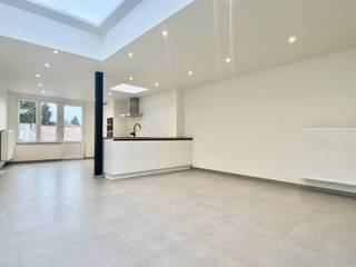 Deze volledig gerenoveerde woning bestaat op het gelijkvloers uit een inkomhal met apart gastentoilet. Er is een leefruimte met open geïnstalleerde keuken (met vaatwasmachine, kookplaat, dubbele spoelbak, dampkap, koelkast, oven, microgolf). <br /><br />Op de eerste verdieping bestaat de woning uit een eerste slaapkamer en ruime badkamer met ligbad, toilet, inloopdouche en wastafel. Via een vaste trap bereikt men de tweede verdieping met twee slaapkamers. Dankzij de hoge plafonds en grote raampartijen wordt een gevoel van openheid gecreëerd. <br /><br />De woning beschikt verder nog over een kelder en een gezellige aangelegde stadstuin. Dankzij de inpandige garage kan men één wagen binnen en één wagen op de oprit plaatsen. Deze woning werd volledig gerenoveerd in een moderne stijl met aandacht en behoud voor authentieke elementen. Uitermate goed gelegen nabij het centrum en nabij op- en afrittencomplex E40. Alarm aanwezig! Huurprijs:1100,- EUR/maand. Onmiddellijk beschikbaar.