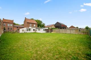 Op zoek naar een woning met ruimte, rust en mogelijkheden? Deze charmante gezinswoning biedt een uitstekende basis om er helemaal uw eigen thuis van te maken. De woning is goed onderhouden, maar kan hier en daar nog wat opgefrist worden, waardoor u de kans krijgt om ze volledig naar uw eigen smaak in te richten.<br />De rustige ligging is één van de grote troeven: u geniet van een aangename woonomgeving met een mooie tuin waar u heerlijk kunt ontspannen, terwijl alle nodige voorzieningen op korte afstand bereikbaar zijn. Scholen, winkels, restaurants en openbaar vervoer bevinden zich vlakbij, wat zorgt voor een ideale combinatie van comfort en bereikbaarheid.<br />Binnenin beschikt de woning over een ruime indeling met maar liefst vier slaapkamers, ideaal voor een gezin of voor wie extra ruimte wenst. De ingerichte keuken sluit aan bij de gezellige leefruimtes, met onder andere twee woonkamers en een aparte eetkamer. Dankzij de verschillende leefruimtes is er volop plaats voor ontspanning, gezellig samenzijn en eventueel een thuiswerkplek.<br />Daarnaast beschikt de woning over een grote garage en twee praktische bergruimtes, waarvan één perfect dienst kan doen als wasplaats. Extra opslagmogelijkheden zorgen voor een aangenaam en georganiseerd wooncomfort.<br />De combinatie van de rustige omgeving, de ruime woning, de mooie tuin en de uitstekende ligging maakt dit een unieke kans voor wie op zoek is naar een ruime gezinswoning met potentieel.<br />Een woning met karakter, ruimte en mogelijkheden, klaar om uit te groeien tot uw nieuwe thuis.