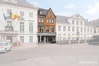 Ontdek dit uitzonderlijk en uiterst ruim handelspand op een absolute toplocatie, pal op de grote markt van Zottegem! Dankzij de uitstekende visibiliteit, de centrale ligging en de grote passage biedt deze eigendom een unieke opportuniteit voor ondernemers die op zoek zijn naar een horecapand met woonst. Met een bruikbare oppervlakte van maar liefst 447 m² op een perceel van 230 m² beschikt dit pand over alle ruimte om een succesvolle horecazaak of andere commerciële activiteit uit te bouwen. Het gelijkvloers verwelkomt u in een bijzonder ruime handelsruimte met een vaste bar en voldoende plaats voor talrijke tafels en zitplaatsen. Op de eerste verdieping bevindt zich een tweede, open gastengedeelte dat rondom de vide is opgebouwd, waardoor bezoekers een mooi uitzicht hebben op het gelijkvloers en het pand een unieke en open uitstraling krijgt. Op dezelfde verdieping is er ook een volledig uitgeruste professionele inox keuken, voorzien van alle nodige installaties voor een vlotte horecawerking, evenals de sanitaire voorzieningen. Boven het commerciële gedeelte bevindt zich de woonst met een ruime leefruimte, twee slaapkamers en een badkamer. Daarnaast beschikt het pand over een grote, volledig geïsoleerde zolder die perfect kan worden ingericht als extra slaapkamers, bureauruimte of polyvalente ruimte, afhankelijk van uw noden. Kortom, een uitzonderlijk handelspand met woonst dat ruimte, karakter en een absolute topligging combineert. Dankzij de toffe inrichting en de uitstekende commerciële ligging vormt deze eigendom een unieke kans voor wie een horecazaak of andere commerciële activiteit wil uitbaten in het bruisende centrum van Zottegem. Contacteer ons vandaag nog voor meer informatie of een vrijblijvend bezoek op het nummer 056 96 08 00 of via info@property-vastgoed.be