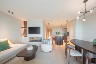 Op de zesde verdieping van de residentie Milenka, in het hart van het Zoute, bevindt zich dit elegant afgewerkt appartement met drie volwaardige slaapkamers en een royaal terras van 18 m². Met zijn bewoonbare oppervlakte van 111 m² en zijn unieke zichten op zee vormt dit appartement een zeldzame combinatie van rust, verfijning en hedendaagse klasse. Slechts één appartement per verdieping, en mogelijkheid tot aankoop van een grote garagebox onder het Albertplein. <br /><br />De lichtrijke leefruimte geniet van brede Skyframe-raampartijen die een panoramisch zeezicht bieden en het natuurlijke licht overvloedig binnenlaten. De open keuken met Miele-toestellen, Travertin werkblad en kasten in walnootfineer sluit naadloos aan bij de eet- en zithoek, wat een bijzonder harmonieus geheel creëert.<br /><br />De drie slaapkamers werden ingericht met oog voor comfort en privacy. Twee beschikken over een ensuite badkamer; de derde kamer heeft een aparte badkamer aan de overzijde van de gang. Verder is er een praktische bijkeuken met was- en droogkast en een afzonderlijk toilet.<br /><br />De afwerking is van hoog niveau, met ingefreesde stopcontacten, ledverlichting in maatkasten, en verfijnde rondingen in natuursteen en schrijnwerk. Elk detail getuigt van een tijdloze esthetiek en doordacht wooncomfort.<br /><br />Extra troef: verkoop onder registratierechten.<br />Private berging in de kelderverdieping.