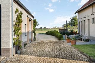 Dans un cadre champêtre et verdoyant, au cœur des champs de Meise, cette ferme rénovée avec goût allie charme rural et confort moderne. Le domaine offre un vaste jardin paysager avec étang idyllique, jacuzzi convivial et espace pour une piscine, idéal pour se détendre en toute sérénité. Les prés attenants se prêtent parfaitement à l’élevage de chevaux ou d’animaux, avec la possibilité de créer des écuries supplémentaires. La grande grange, déjà équipée en eau et électricité, ouvre de nombreuses perspectives : espace de travail, stockage, logement d’invités ou salle de loisirs. Une lumineuse pièce, accessible séparément, peut servir de bureau pour indépendants ou être transformée en suite parentale avec vue panoramique sur les champs. Les amoureux de chevaux apprécieront l’accès direct aux prés et aux chemins de campagne pour de belles balades. Bien que nichée dans un écrin de nature, la propriété se situe au centre du village et bénéficie de liaisons rapides vers Bruxelles et les communes avoisinantes. Cette perle rare conjugue caractère, espace et liberté, idéale pour cavaliers, entrepreneurs ou familles en quête de tranquillité.