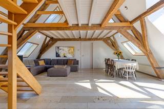 Welkom in de historische Dossin Kazerne in Mechelen!<br /><br />Dit uniek appartement combineert karaktervol erfgoed en authentieke elementen met hedendaags comfort. In het appartement zijn maar liefst 4 slaapkamers, 2 badkamers aanwezig en de mogelijkheid tot het inrichten van een volledig extra verdiep. Gelegen op een uitzonderlijke en centrale locatie op wandelafstand van het centrum van Mechelen, en kortbij de ring.<br /><br />Het appartement beschikt over een grote inkom met gastentoilet, dat uitgeeft op de zeer ruime en gezellige leefruimte. Hier zie je de authentieke elementen en houten draagstructuur wat voor een enorm charme niveau zorgt. De keuken sluit hier netjes op aan en is zojuist gemoderniseerd. Naast de keuken tref je een handige berging en wasplaats. In de woonkamer is ook een dakkapel met terras. (uitzicht op de Sint-Rombouts)<br /><br />Er zijn op het eerste niveau 3 zeer ruime slaapkamers aanwezig, waarvan één met en-suite badkamer én een sauna! Verder is er nog een 2de gemeenschappelijke badkamer op de gang. Het complex heeft een fietsenberging, en 3 vrije staanplaatsen voor bewoners.<br /><br />Boven de woonkamer bevindt zich de 'mesanine', waar je de laatste slaapkamer terugvindt en bovendien een volledig verdiep dat nog kan ingericht worden als extra woonkamer/slaapkamer/hobbyruimte/... Het appartement is ook energiezuinig met een EPC score B!<br /><br />Kortom, dit is een zeldzame opportuniteit voor wie op zoek is naar ruimte, historisch karakter en een uitstekende ligging in hartje Mechelen!