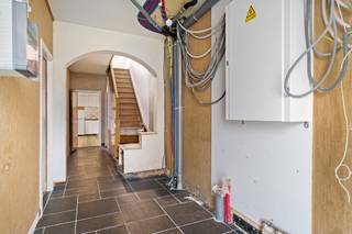 Deze op te frissen woning is erg centraal gelegen tussen de dorpen Ekeren, Kapellen en Hoevenen. Ook de autosnelweg, het openbaar vervoer en scholen vindt u in de directe omgeving. In de woning werden de afgelopen jaren reeds verschillende energetische verbeteringen uitgevoerd, waaronder een vernieuwd dak, nieuwe ramen, een geïsoleerde voorgevel en een condenserende CV-ketel voor de bovenverdiepingen. Tegelijkertijd dient de woning op bepaalde vlakken nog verder afgewerkt en gemoderniseerd te worden, wat u de mogelijkheid geeft om ze verder naar eigen smaak in te richten. Binnenkomen doet u hier via een aparte inkomhal, welke meteen uitgeeft in de aangename leefruimte met aangrenzend een eenvoudig ingerichte keuken. Op het gelijkvloers is verder nog een veranda aanwezig, waar u kan genieten van een fijn uitzicht over de tuin. In de veranda is bovendien nog een aparte toiletruimte. De trap in de inkomhal brengt u naar de nachthal op de 1e verdieping, dewelke de verbinding vormt tussen de badkamer en de 2 volwaardige slaapkamers. De recent vernieuwde badkamer is tot boven toe betegeld en beschikt over een ligbad met douche, toilet, handdoekradiator en dubbele wastafel met meubel. Een vaste trap leidt verder naar de 2e verdieping, waar zich nog een gigantische master-bedroom bevindt. Dankzij de royale oppervlakte bestaat hier de mogelijkheid om de ruimte op te splitsen in 2 aparte slaapkamers. Tot slot heeft de woning ook nog een praktische, droge kelder, waarin heel wat materiaal opgeborgen kan worden. Het perceel heeft een totale oppervlakte van 390m². De oostelijk georiënteerde tuin met terras vormt een fijne plek om in alle rust en privacy van het buitenleven te genieten.
