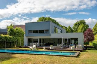 GELIJKVLOERSInkomhal 13m² op tegel met gastentoilet en handenwasser.Bureel 10m² op parket met kastenwand.Woonkamer 40m² op tegel met vast tv-meubel...