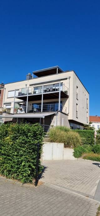 <strong>Welgelegen en perfect onderhouden DUPLEX APPARTEMENT (bj '04) met hoogwaardige afwerking van  138 m² met een  terras van 60 m² en aparte ondergrondse garage. Lift komt tot in het appartement zelf.</strong><br />Indeling: inkom, apart wc met lavabo, hall met inbouwkast, ruime living met full option ingerichte keuken, berging/wasplaats,  groot terras, verdiep: 3 ruime slaapkamers (één met inbouwkasten), volledig ingerichte badkamer met hoekbad, douche, dubbel lavabomeubel, apart wc met lavabo;  garage en aparte kelder. Vloeren: tegels + laminaat; cv aardgas, gashaard + airco. De slaapkamers zijn op de 2de verdieping en de leefruimten op de 3 verdieping.<br />Directe  verbindingen met E40, station, Centrum, winkels,…<br /> 