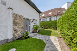 Deze goed onderhouden koppelvilla met 3 slaapkamers is bijzonder gunstig gelegen in de Julius Sabbelaan te Knokke. De woning bevindt zich aan de achterkant van het perceel in een rustige en aangename omgeving, op slechts 280 meter van de zeedijk, 500m van het casino en amper 150 meter van het Zegemeer. Een uitstekende ligging die rust en privacy combineert met een vlotte bereikbaarheid van de kust en het centrum van Knokke.<br /><br />Via de inkomhal met vestiaire en gastentoilet komen we in de ruime en lichtrijke woonkamer. Deze aangename leefruimte is voorzien van een stijlvolle parketvloer in visgraatmotief en werd praktisch ingedeeld met een gezellige zithoek en aparte eethoek. Aansluitend bevindt zich de keuken, die werd uitgerust met kwalitatieve materialen.<br /><br />Vanuit de woonkamer is er rechtstreeks toegang tot het ruime zonneterras. Dankzij de aanwezige zonneluifel en windschermen kan hier optimaal worden genoten van het zuidgerichte terras, zowel op zonnige als meer winderige dagen.<br /><br />Op de verdieping geeft de nachthal toegang tot de 3 slaapkamers en het aparte toilet. De 2 ruime slaapkamers beschikken over ingebouwde kasten en hebben elk hun eigen ensuite badkamer, waarvan één is uitgerust met een ligbad en de andere met een douche. De derde slaapkamer is momenteel ingericht als ruime dressing en beschikt eveneens over praktische inbouwkasten.<br /><br />De volledige woning is onderkelderd en biedt hierdoor heel wat extra ruimte. Hier bevinden zich onder meer een inpandige garage en verschillende praktische bergruimtes.<br /><br />Ook buiten heeft deze villa heel wat te bieden. De volledig aangelegde tuin vormt een aangename groene omgeving en beschikt over een tuinhuis en een grasrobot, wat het onderhoud aanzienlijk vereenvoudigt.<br /><br />Een charmante koppelvilla met een zeer gunstige ligging in de Julius Sabbelaan, op wandelafstand van de zeedijk en het Zegemeer, en met tal van mogelijkheden om de woning verder naar eigen smaak te moderniseren.