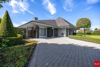 Deze charmante villa is uitstekend gelegen op een vlot bereikbare locatie, op korte afstand van het centrum van Oostmalle. Hier geniet u van een ideale combinatie van rust, ruimte en bereikbaarheid. Bovendien bestaat de mogelijkheid om de achtergelegen weilanden bijkomend aan te kopen.<br /><br />INDELING:<br /><br />Via de mooie oprit bereikt u de woning. Bij het binnenkomen wordt u verwelkomd in een ruime inkomhal. Rechts bevindt zich de lichtrijke leefruimte, die dankzij de vele raampartijen geniet van een aangename lichtinval en een prachtig uitzicht biedt op de fraai aangelegde tuin. Aansluitend bevindt zich de volledig uitgeruste keuken, die rechtstreeks toegang verleent tot het gezellige terras.<br /><br />Links van de inkomhal bevindt zich het slaapgedeelte. De woning beschikt over drie ruime slaapkamers en twee comfortabele badkamers. De eerste badkamer is uitgerust met een enkele lavabo, een ligbad en een toilet. De tweede badkamer beschikt over een dubbele lavabo en een inloopdouche. Via deze badkamer bereikt u bovendien een praktische bureauruimte, een wasplaats en een extra toilet.<br /><br />Verder beschikt de woning over een ruime bergzolder, wat zorgt voor extra opslagmogelijkheden.<br /><br />Buiten geniet u van een prachtig aangelegde, volledig omheinde tuin waar u in alle rust kunt ontspannen. Achter de afsluiting bevindt zich nog een extra perceelsgedeelte met een garage, een opslagplaats en een ruim magazijn. Deze bijkomende gebouwen bieden tal van mogelijkheden voor hobbyisten, zelfstandigen of wie op zoek is naar extra bergruimte.<br /><br />Kortom, een ruime en veelzijdige woning met een uitstekende ligging, ideaal voor gezinnen of wie wonen en werken wenst te combineren.<br /><br />BIJZONDERHEDEN: <br />- Goede bereikbare locatie<br />- Veel mogelijkheden <br />- Veel ruimte<br />- Aangelegde tuin<br /><br />Voor meer info of een bezoek ter plaatse kan u vrijblijvend contact opnemen met Lieselotte op 03.227.58.58 of lieselotte@reds.be.