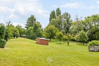 In het centrum van Kuurne vinden we deze statige herenwoning met tal van authentieke elementen en een uitzonderlijk perceel van 2.659 m². Een eigendom met veel potentieel voor wie ruimte, karakter en een centrale ligging weet te waarderen.<br /><br />De imposante inkomhal met glas-in-loodkoepel, marmeren afwerkingen en authentieke trappenhal zet meteen de toon. Vooraan bevinden zich een afzonderlijk bureau of praktijkruimte en een vestiaire. De leefruimte charmeert met haar hoge plafonds, mooie parketvloer en originele glas-in-looddetails.<br />Aansluitend bevindt zich de ruime keuken met veel lichtinval. Achteraan vinden we het terras en verschillende praktische bergingen.<br /><br />Op de verdieping vinden we vijf volwaardige slaapkamers, een badkamer met bad en douche en een apart toilet. De ruime zolder, bereikbaar via een vaste trap, biedt mogelijkheden voor bijkomende kamers of een hobbyruimte. Verder beschikt de woning over een droge kelder en een diepe garage.<br /><br />De absolute troef van deze eigendom bevindt zich achteraan. Het diepe perceel grenst aan de Heulebeek en geniet van een prachtig open zicht op het omliggende groen. Een zeldzame combinatie van wonen in het centrum met een verrassend landelijk gevoel. Achteraan bevindt zich bovendien een charmant landhuisje dat perfect dienst kan doen als tuinberging, atelier of hobbyruimte.<br /><br />Een karaktervolle woning met een rijke geschiedenis, authentieke architectuur en heel wat mogelijkheden, klaar om verder opgefrist te worden naar hedendaagse woonnormen.