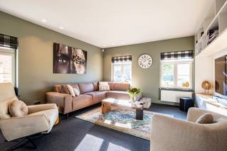 <p><strong>Instapklare en bijzonder verzorgde villa met 4 slaapkamers, 2 badkamers, kantoorruimte, 2 garages en carport, gelegen op een mooie locatie in Ravels. De woning bevindt zich op een west georiënteerd perceel met een volledig afgesloten tuin en een heerlijk overdekt terras. Dankzij de doordachte indeling, de kwalitatieve afwerking en de gunstige energiescore van 115 KwH is dit een ideale gezinswoning waar u zonder zorgen kunt intrekken.</strong></p>
<p>Een prachtige inkomhal heet u van harte welkom. Meteen bij het binnenkomen valt op met hoeveel zorg en oog voor detail deze woning werd ingericht en onderhouden. De inkomhal is voorzien van een vestiaire, gastentoilet en trap naar de verdieping en geeft rechtstreeks toegang tot de leefruimte. De woonkamer is aangenaam ingedeeld in een gezellige zithoek aan de straatzijde en een ruime eetkamer aan de tuinzijde. Een stijlvolle roomdivider zorgt voor een subtiele scheiding tussen beide ruimtes, terwijl u zowel vanuit de zithoek als vanuit de eetkamer kunt genieten van de warmte en sfeer van de haard. Grote raampartijen zorgen bovendien voor een mooie natuurlijke lichtinval en een prettig contact met de tuin. Aansluitend bevindt zich de zeer verzorgde keuken, die dankzij haar open verbinding met de eetkamer bijzonder gezellig aanvoelt. Terwijl u kookt, blijft u betrokken bij uw gezin of gasten en ook voor een aperitief aan het ruime werkblad is er meer dan voldoende plaats. De keuken verkeert in uitstekende staat en is voorzien van een groot werkblad, de nodige inbouwtoestellen en veel praktische bergruimte. Naast de keuken bevindt zich de ruime bijkeuken, ingericht met plaats voor wasmachine en droogkast, extra opbergmogelijkheden en een volwaardige douche. Een absolute meerwaarde is de recent ingerichte kantoorruimte. Deze werd stijlvol afgewerkt met maatwerkkasten en een fraai fineer werkblad met ruimte voor twee werkplekken. Dankzij de stalen ramen en deur blijft het contact met de leefruimte behouden, terwijl u de ruimte indien gewenst rustig kunt afsluiten.</p>
<p><strong>Verdieping <br /></strong>Via de lichtrijke overloop bereikt u drie ruime slaapkamers, een volledig vernieuwd apart toilet en de badkamer. De master bedroom bevindt zich aan de tuinzijde en geniet van een mooi uitzicht over het groen. Deze kamer beschikt over airconditioning en een ruime inloopdressing. Ook de overige slaapkamers zijn volwaardig van formaat, waarbij de grootste slaapkamer zich aan de straatzijde bevindt. De volledig vernieuwde badkamer is bijzonder stijlvol afgewerkt. De natuurlijke lichtinval en de hoogwaardige materialen zorgen voor een luxueuze uitstraling. De badkamer is uitgerust met een dubbele wastafel en een zeer ruime inloopdouche, waardoor u hier elke dag van een echt wellnessgevoel geniet.</p>
<p><strong>Zolderverdieping <br /></strong>Ook de zolderverdieping werd optimaal benut en is gemakkelijk bereikbaar via een vaste trap. Hier bevindt zich een ruime vierde slaapkamer die eveneens uitstekend dienst kan doen als hobby-, speel- of werkruimte. Daarnaast zijn er nog twee royale bergruimtes aanwezig. Zelfs deze ruimtes werden netjes en duurzaam afgewerkt.</p>
<p><strong>Tuin <br /></strong>buiten is het heerlijk vertoeven. Het west georiënteerde perceel laat u volop genieten van de namiddag- en avondzon. Het ruime overdekte terras vormt daarbij een echte verlenging van de leefruimte. Op warme dagen geniet u er aangenaam in de schaduw, terwijl u dankzij de aanwezige verwarming ook tijdens koelere momenten comfortabel buiten kunt blijven zitten. Vanop het terras kijkt u uit over de verzorgde, groene tuin, waar u bijzonder rustig en discreet zit. De tuin is volledig afgesloten en daardoor ideaal voor gezinnen met kinderen of huisdieren. Achteraan bevinden zich bovendien twee garages en een carport, waardoor er bijzonder veel parkeer- en opslagruimte beschikbaar is. Eén van de garages beschikt daarnaast over een volwaardige kelder.</p>