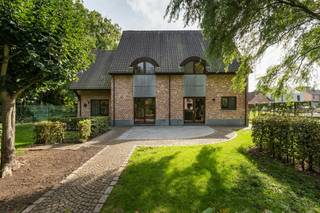 In de residentiële omgeving van Zolder bevindt zich deze imposante villa op een uitgestrekt, volledig omheind perceel van circa 80 are. Dit karaktervolle landhuis combineert een royale bewoonbare oppervlakte van circa 420 m² met een uitzonderlijk gevoel van rust, ruimte en privacy. Dankzij de ligging aan een verkeersluwe cul-de-sac, grenzend aan waardevol landbouw- en natuurgebied, geniet u hier van een blijvend vrij uitzicht en een serene woonomgeving. Tegelijk bevinden het station van Zolder, diverse voorzieningen en het park Op den Aenhof zich op wandel- of korte fietsafstand.<br /><br />Bij het betreden van de villa verwelkomt een voorname inkomhal u in een interieur waar ruimte en natuurlijk licht centraal staan. De royale leefruimte met salon en formele eethoek sluit harmonieus aan op de volledig ingerichte leefkeuken, uitgerust met kwalitatieve inbouwtoestellen, ruime werkbladen en veel opbergruimte. Grote raampartijen bieden een prachtig uitzicht over de omliggende tuin en weidegronden.<br /><br />Op de verdieping bevinden zich vier volwaardige slaapkamers, twee ingerichte badkamers en een ruime polyvalente ruimte. Deze laatste biedt tal van mogelijkheden, onder meer voor een private studio, kangoeroewonen of co-housing. Ook een vrij beroep, praktijk of kantoor aan huis behoort dankzij de royale volumes tot de mogelijkheden.<br /><br />De villa is volledig onderkelderd en beschikt over een authentieke wijnkelder, ruime provisieruimtes en een polyvalente hobby- of werkplaats. De dubbele inpandige garage biedt plaats aan twee wagens. De woning werd opgetrokken met hoogwaardige en duurzame materialen, verkeert in een uitstekende staat van onderhoud en beschikt over een gunstig energielabel B.<br /><br />Buiten vormt het uitgestrekte domein een absolute troef voor liefhebbers van natuur en dieren. De aanpalende weide is uitermate geschikt voor paarden, schapen of ander kleinvee, terwijl de aangelegde tuin is voorzien van een praktische tuinberging, een beregeningsinstallatie en zonovergoten terrassen waar men in alle privacy geniet van het ongerepte natuurlandschap.<br /><br />Een uitzonderlijke eigendom waar royaal wonen, veelzijdige gebruiksmogelijkheden en landelijke sereniteit op harmonieuze wijze samenkomen.<br /><br />De gepubliceerde prijs is een instelprijs.<br /><br />Voor meer informatie of een bezoek ter plaatse, contacteer uw vastgoedmakelaar Cédric Larbie via 0496 20 59 58 of cedric.larbie@dewaele.com.<br /><br /><br /><br />Bestuursmaatregelen in het maatregelenregister: nee