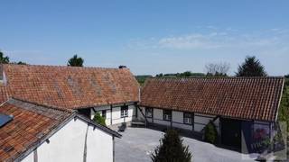 Ontdek deze uitzonderlijke woning, genesteld in het groen aan de Slaapstraat 29 in Alken, op een volledig privatief perceel van maar liefst 11.974 m². Hier ervaart u ultieme rust, absolute privacy en royale leefruimte – een permanente vakantiesfeer in uw eigen huis. Met een bewoonbare oppervlakte van 297 m² (volgens EPC) biedt deze villa een perfecte mix van elegantie, comfort en functionaliteit.<br /><br />De woning verwelkomt u met een ruime inkomhal en een aparte bureauruimte, gevolgd door een gastentoilet, een lichte eetkamer en een gezellige leefruimte met doorkijkhaard. De volledig uitgeruste keuken grenst aan een lichtrijke veranda, ideaal om het hele jaar door te genieten van het uitzicht op de groene tuin. Op het gelijkvloers bevinden zich daarnaast twee slaapkamers met directe toegang tot het terras, een garage met zolderberging en een praktische wasruimte met uitgang naar de tuin.<br /><br />Het buitenleven wordt hier naar een hoger niveau getild: het royale terras met een ingebouwd zwembad en een stijlvol poolhouse met bar vormt het absolute pronkstuk van de woning – perfect voor zomerse ontspanning en sfeervolle avonden met vrienden en familie.<br /><br />Op de verdieping zorgen een open vide, een luxueuze badkamer met ligbad en douche, en een extra slaapkamer met airco voor comfort en privacy. Dankzij zonnepanelen en een warmtepomp combineert deze woning haar authentieke charme met moderne, energiezuinige technologie. Het EPC bedraagt 322 kWh/m² jaar (label D).<br /><br />Een unieke kans voor wie verlangt naar ruimte, natuur en serene rust op een toplocatie in Alken.<br /><br />🔑 Laat u betoveren – contacteer ons vandaag nog voor een exclusief bezoek.