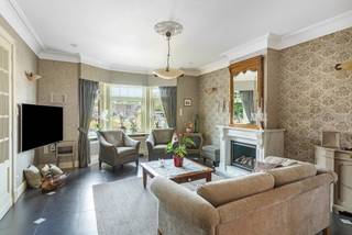 <p>Dit stijlvolle herenhuis in Dessel is gelegen op een perceel van 875 m² en heeft een bewoonbare oppervlakte van ca. 302 m².</p>
<p><strong>Gelijkvloers</strong></p>
<p>Bij het betreden van de inkomhal wordt meteen duidelijk dat dit een huis met karakter is. Rechts bevindt zich een eerste slaapkamer met badkamer, voorzien van een douche, lavabo en toilet – ideaal als luxueuze gastenruimte.</p>
<p>Verder leidt de inkomhal naar de ruime, gezellige leefruimte. Dankzij de sfeervolle gashaard kunt u in de zithoek tijdens kille winteravonden in alle comfort genieten. Verder bestaat de leefruimte nog uit een eetkamer en een open bureaugedeelte.</p>
<p>De keuken sluit mooi aan op de leefruimte en biedt niet alleen een praktische indeling, maar ook een prachtig uitzicht op de aangelegde tuin. Dankzij de grote ramen geniet u hier van overvloedig daglicht en een aangename openheid.</p>
<p>Op het gelijkvloers bevindt zich tevens een apart gastentoilet.</p>
<p><strong>Eerste verdieping</strong></p>
<p>De elegante trap brengt u naar de eerste verdieping, waar u maar liefst 4 slaapkamers aantreft. De master bedroom beschikt over een eigen inloopkast en badkamer, uitgerust met douche, lavabo en toilet. Daarnaast beschikt de eerste verdieping over een extra badkamer uitgerust met een bad en een dubbele lavabo. Hiernaast bevindt zich een apart toilet.</p>
<p><strong>Zolder</strong></p>
<p>De vaste trap leidt verder naar de grote zolderverdieping. Deze riante ruimte biedt talloze mogelijkheden en kan volledig naar wens worden ingericht – bijvoorbeeld als extra slaapkamers, hobbyruimte of atelier.</p>
<p><strong>Tuin en garage</strong></p>
<p>De prachtig aangelegde en uitstekend onderhouden tuin vormt een oase van rust, waar u volop kan genieten van de buitenlucht.</p>
<p>Links van de woning bevindt zich de ruime garage.</p>
<p><strong>Kelder</strong></p>
<p>Er is een droge kelder onder de helft van de woning en de andere helft is een vlot toegankelijke kruipruimte.</p>
<p><strong>Extra’s</strong></p>
<p>Dit herenhuis combineert zijn statige uitstraling met moderne voorzieningen. Zo is de woning uitgerust met zonnepanelen, airco en thuisbatterij en geniet u van een gunstig energielabel.</p>
<p><strong>Troeven</strong></p>
<ul>
<li>Bewoonbare oppervlakte: ca. 302 m²</li>
<li>5 slaapkamers</li>
<li>Vaste trap naar de grote zolder</li>
<li>Ruime, aangelegde tuin</li>
<li>Gunstig energielabel (164 kWh / (m² jaar))</li>
<li>Zonnepanelen, thuisbatterij, airco</li>
</ul>