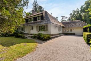 In the heart of the green Schoten, in the sought-after residential area of De Zeurt, you will find this detached villa on a spacious plot of 4,910 m². The property offers complete privacy, a southwest-facing garden with mature landscaping, and a rare range of amenities, including an indoor swimming pool, sauna, and garage. Thanks to its location in a dead-end street, you can enjoy absolute tranquility while schools, shops, and the center of Schoten are within easy reach.<br /><br />Layout<br />Ground floor:<br />The villa welcomes you via a private driveway with ample parking. In the entrance hall, there is a cloakroom, guest toilet, and access to the basement and first floor. The bright living room of approx. 51 m², equipped with a fireplace and floor-to-ceiling windows, offers a view and access to the garden. Adjacent to the living room is the kitchen (approx. 11 m²) with direct access to the covered terrace.<br /><br />The ground floor also houses the master bedroom (approx. 20 m²) with an en suite bathroom, equipped with a bathtub, spacious shower, double sink, and toilet.<br /><br />First floor:<br />On the first floor, there are three bedrooms (approx. 34 m², 13 m², and 11 m²), a separate dressing room (approx. 9 m²), and a second bathroom with a bathtub, double sink, and toilet.<br /><br />Attic & basement:<br />The property is fully basemented and has a spacious attic, accessible via a fixed staircase from the landing.<br /><br />Outdoor area<br />The garden is a real asset: fully southwest-facing, with a natural forest edge, maximum privacy, and beautiful views from the living spaces. The wellness area includes a spacious indoor swimming pool, sauna (approx. 6 people), shower, and toilet. A large covered terrace on the kitchen side allows for outdoor living all year round. The garage with attic and the garden shed offer additional storage options.<br /><br />Advantages:<br />- Roof renovated in 2002<br />- Heating via gas condensing boiler (2012) + underfloor heating<br />- PVC windows with high-efficiency glass<br />- Natural areas such as the Peerdsbos and Vordenstein in the immediate vicinity<br /><br />Ideal for those looking for a co-housing concept, a granny flat, or a home office<br /><br />Worth a visit<br />This characterful villa with unique amenities and an exceptional plot is a great opportunity for those who love space, privacy, and nature. Contact us to schedule a visit.