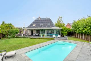Welkom in deze moderne, instapklare villa uit 1995 van 243m² (excl. garage)op een perceel van 851m² in de Spiltstraat 55 te Zemst. Deze woning onderscheidt zich door de hoge afwerkingsgraad, uitstekende staat van onderhoud en prachtig aangelegde zuidwestgerichte tuin met zwembad en poolhouse. U wordt verwelkomd via een ruime inkomhal met gastentoilet en vestiaire. De lichtrijke leefruimte met gashaard en parketvloer straalt warmte en gezelligheid uit. Vanuit de veranda (2014) geniet u van een panoramisch zicht op de tuin dankzij de grote raampartijen die de ruimte overladen met natuurlijk licht. Alle ramen op het gelijkvloers werden in 2017 vernieuwd en een aantal zijn voorzien van automatische screens. Aansluitend vindt u de volledig uitgeruste keuken met Miele-toestellen (2011), inclusief een stoomoven, klassieke oven, vaatwas op hoogte, grote koelkast en een mooi kookeiland met inductie kookplaat. Naast de keuken bevindt zich een praktische bijkeuken/berging en een ruime garage/berging. Op de eerste verdieping vindt u een nachthall met bureauhoek (15 m²) en 3 ruime slaapkamers, waaronder een master bedroom van 17 m² met ingebouwde kasten en twee kamers van elk 15m². De badkamer werd vernieuwd in 2021 en is uitgerust met een inloopdouche, dubbele wastafel, toilet en vloerverwarming. Daarnaast zijn op de verdieping ook alle veluxen voorzien van automatische rolluiken. De zuidwestgerichte tuin biedt heel wat ontspanning met een overdekt terras (25m²) met louvredak, verwarmd zwembad (2005) en een poolhouse (23m²) met douche en sauna. De woning is zeer energiezuinig met een EPC-label A en beschikt over 48 zonnepanelen (2016). Andere voorzieningen zijn: een waterverzachter, elektrische boiler, ... De centrale ligging in Zemst combineert rust en groen met een uitstekende bereikbaarheid richting Mechelen, Brussel en Antwerpen. Scholen, winkels, sportfaciliteiten en natuur zijn bovendien vlakbij. Elektrische installatie is conform!