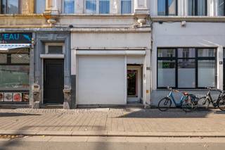 <p>Aan de Handelstraat 85, een winkelstraat in de wijk Stuivenberg, staat dit handelspand met woonst en achterbouw, opgetrokken omstreeks 1910 à 1920. Het ligt op een perceel van 146 m² met een gevelbreedte van ongeveer 5,1 m en een diepte van ongeveer 28,4 m, en heeft een totale nuttige oppervlakte van ongeveer 451 m². Winkels, scholen en ziekenhuizen liggen in de buurt, er zijn verschillende tram- en bushaltes binnen een straal van 1 km en de op- en afrit Borgerhout van de R1 ligt op ongeveer 2,4 km. Het pand is minder goed onderhouden en een grondige renovatie is aangewezen, maar het biedt veel ruimte en heeft nog heel wat authentiek karakter.<br /><br />Indeling<br />Aan de straatkant zijn er een rolluik voor de handelsruimte. Het gelijkvloers deed dienst als restaurant: een diepe ruimte met linoleumvloer, zichtbare houten balkjes aan het plafond en een trap naar de verdieping. Daarachter liggen de bediening, de keuken met eenvoudige industriële uitrusting, een wasplaats, twee toiletten, een hal en een bergplaats.<br />Op de eerste verdieping vooraan liggen de living en de eetkamer, met stucwerk aan het plafond en een schouw met kachel. Verder is er een eenvoudige keuken met stenen aanrecht met twee bekkens en een badkamer met bad, twee lavabo's, toilet en elektrische boiler, beide met een granito vloer.<br />De tweede verdieping telt twee slaapkamers, elk met een schouw. Op de zolderverdieping vooraan liggen nog twee kamers met dakvensters. Doorheen het pand vind je authentieke elementen zoals marmeren schouwen, een trap met gedraaide balusters en een binnendeur met geëtst glas.<br />De achterbouw heeft op de eerste verdieping en op de zolderverdieping telkens een hal, een voorkamer en een achterkamer met houten vloer. Hij is slecht onderhouden en heeft geen comfort: de vloerplaat van het gelijkvloers is ingezakt en moet vervangen worden.<br />Vooraan is het pand onderkelderd, met onder meer een stookkelder, mazoutkelder en bergkelder. Ook onder de achterbouw zijn er kelders, die momenteel niet toegankelijk zijn.<br /><br />Buiten<br />Achteraan is er een verharde koer, noord georiënteerd, met toegang tot een overbouwde doorgang naar de straat. Het perceel is deels bezwaard met een recht van doorgang en heeft zelf een recht van doorgang via die gang naar de achterbouw.<br /><br />Technisch<br />Centrale verwarming op mazout, met tank en ketel in de kelder vooraan. Het schrijnwerk is deels PVC met isolerend glas en deels ouder met enkel glas. Volgens het EPC zijn het hellende en het platte dak niet geïsoleerd.<br /><br />Troeven: handelsgelijkvloers met aparte inkom, 146 m² grond, ongeveer 451 m² nuttige oppervlakte, woonst met 2 slaapkamers en 2 zolderkamers, achterbouw met 4 bijkomende kamers, authentieke elementen.<br /><br />EPC: 682 kWh/m².jaar, label F, UC 20260915-0003951521-RES-1<br />Stedenbouwkundige info: stedenbouwkundige vergunning van 29/10/1965, gewestplan woongebied, gemeentelijk RUP 2060 (zone voor detailhandel), geen verkavelingsvergunning, voorkooprecht RUP 2060.<br />Overstromingsgevoeligheid: P-score A, G-score A.<br />Asbestattest: attestnummer 20260921-000087.000 van 21 september 2026, conclusie niet-asbestveilig.<br /><br />Interesse? Contacteer ons voor een bezoek.</p>