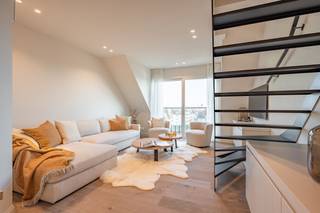 Uitzonderlijke nieuwbouw duplex-appartement op een toplocatie met zijdelings zeezicht. Indeling: inkomhal met vestiaire en toilet. Ruime lichtrijke woonkamer met bureau en toegang tot het terras met zijdelings zeezicht. Moderne ingerichte keuken (met Miele toestellen) en eetplaats. Ingebouwde wasmachine en droogkast. 1ste verdieping: 2 volwaardige slaapkamers met ingemaakte kasten. Ruime badkamer. Mogelijkheid om de meubelen aan te kopen. Airco in het volledige appartement. Splitsing grond- en construtiewaarde. De gemene delen van het gebouw werden reeds integraal opgefrist.