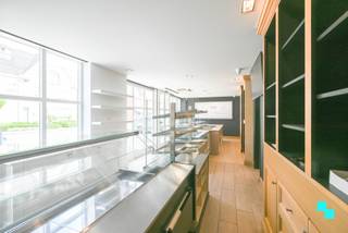 Deze instapklare eigendom in het centrum van Nieuwenhove (Waregem) biedt maar liefst 495 m² bruikbare oppervlakte (volgens EPC-attest) op een zonnig en zuidgericht perceel. De voormalige bakkerij werd gecombineerd met een ruime privéwoning met vijf slaapkamers, een werkgedeelte en afzonderlijke handelsruimte. Dankzij de voorliggende parking, carport en inpandige garage zijn er diverse parkeermogelijkheden. De winkelruimte, momenteel ingericht als bakkerij, is professioneel en kwalitatief afgewerkt, met achterliggend een atelier voorzien van o.m. koel- en diepvriescel. De zolder boven het atelier biedt extra stockage. Het privatieve deel, volledig afgescheiden en momenteel verhuurd, omvat een lichtrijke leefruimte met zithoek en houthaard, eetplaats, uitgeruste keuken met granieten werkblad en een praktische wasplaats/berging. De zuidgerichte tuin biedt maximale privacy, een tuinhuis en doorgang naar carport en atelier. Op de verdieping bevinden zich een nachthal, vernieuwde badkamer (2018), berging en vier slaapkamers, waarvan één toegang geeft tot een afgewerkte studio met eigen douchekamer en zolderruimte. Dankzij de flexibele indeling kan de woning verder verhuurd worden of eenvoudig opnieuw als één geheel worden benut. Voor meer foto's en informatie, surf naar www.bordes.be