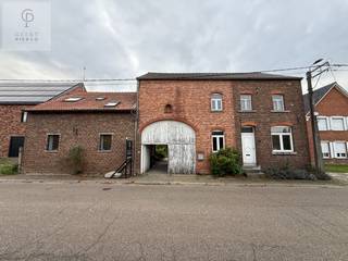Authentiek wonen met ruimte voor jouw plannen<br /><br />Voor het bezichtigingen van alle foto's, neem een kijkje op onze eigen website, www.pierco.be, hier vindt je de volledige fotoreportage<br /><br />Sommige woningen hebben dat tikkeltje meer.<br />Een eigen verhaal, bijzondere details en ruimte die je blijft verrassen.<br /><br />Deze karaktervolle eigendom op een perceel van 11 are, met een bewoonbare oppervlakte van 322,65 m², is zo’n plek.<br /><br />De authentieke gewelfde plafonds, de royale volumes en de diepe tuin met zicht op de achterliggende weilanden maken dit tot een woning met een heel eigen uitstraling.<br /><br />De voormalige schuur en stalling werden destijds ingericht als uitbreiding van de woning, waarvoor in 1998 een vergunning werd afgeleverd.<br />Daarbij bleven de prachtige bakstenen gewelven behouden.<br />Ze geven de leefruimtes een warme, bijzondere sfeer en vormen de blikvanger van dit gedeelte.<br /><br />De oorspronkelijke woning aan de rechterzijde wordt momenteel voornamelijk als stockage gebruikt, maar biedt heel wat mogelijkheden om opnieuw bij het dagelijkse wonen te betrekken.<br /><br />Op het gelijkvloers bevinden zich een keuken, eetkamer, leefruimte en badkamer.<br />De trap in de leefruimte leidt naar een overloop met toegang tot twee afzonderlijke kamers en een bureauruimte.<br /><br />Op de eerste verdieping verbindt een doorgang de oorspronkelijke woning met het verbouwde gedeelte.<br />Daar bevinden zich nog een badkamer en drie afzonderlijke kamers, waaronder een bijzonder ruime kamer met mezzanine.<br /><br />Afhankelijk van de gewenste indeling zijn er mogelijkheden om een zestal slaapkamers te voorzien.<br /><br />De nog onbenutte zolder van de oorspronkelijke woning biedt bovendien potentieel voor een bijkomende, zevende kamer.<br /><br />Dankzij de twee verbonden woongedeelten is dit een interessante eigendom voor een groot gezin of voor wie wonen, werken en hobby’s onder één dak wil combineren.<br /><br />Ook wie droomt van kangoeroewonen vindt hier een veelbelovende basis, mits de nodige stedenbouwkundige afstemming.<br /><br />Buiten wacht een heerlijke tuin met ruimte om te ontspannen, te spelen en te genieten van het landelijke uitzicht.<br /><br />De achterliggende weidelanden zorgen voor een open, groen decor dat mee het karakter van deze eigendom bepaalt.<br /><br />Het perceel ligt deels in woongebied met landelijk karakter en deels in agrarisch gebied, waarbij vooral het achterste gedeelte van de tuin binnen de agrarische bestemming valt.<br /><br />Zoek je een woning met karakter, veel ruimte en mogelijkheden om jouw eigen woonverhaal te schrijven?<br /><br />Dan is dit een plek die je zelf moet komen ontdekken.<br />