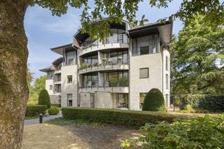 OPEN HUIS ZATERDAG 6 DECEMBER van 10u tot 11u ! In dit prachtige parkdomein, helemaal in het groen en toch overal vlakbij, wil je wonen: vlakbij de winkelstraten, het Stadspark, de ring, Carrefour, ziekenhuis ... alles op loopafstand ! Echt een topligging! Het appartement valt onmiddellijk op door zijn bijzondere architectuur en indelling: vooral de woonkamer met vide / mezzanine en veel lichtinval geven je onmiddellijk een geweldig gevoel van ruimte. De woonkamer heeft een mooie parketvloer en moderne, vaste kasten. De mezzanine is ideaal als lees-/tv-hoek, bureelruimte (thuiswerk!), cosy lounge ruimte, hobbyruimte, logeerruimte ... Aansluitend aan de woonkamer: ruime zuidwestgericht terras om van de middag- en avondzon te genieten. De keuken is volledig ingericht met kookplaat, vaatwasser, koelkast en diepvriezer, combi-oven en heeft een granieten werkblad en veel kastruimte. Aansluitend aan de keuken is er een ruime berging / wasplaats. Verder nog 2 slaapkamers, met aansluitend een oostgericht terras, ideaal om in de ochtendzon te ontbijten bv, en een praktisch ingedeelde badkamer met douche én bad en een tweede toilet. Inkom met gastentoilet. Het appartement is gelegen in een zeer net gebouw, op een mooi omheind domein. Garage op het terrein verplicht bij aan te kopen aan € 20.000. - Niet gelegen in een overstromingsgebied - P-score: D, G-score: C