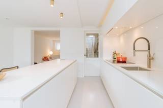 <p>Op een prachtige plek in Lier, vlak bij de dijk en op korte afstand van het centrum, vinden we dit hoogwaardig afgewerkte herenhuis. Achter de karaktervolle gevel schuilt een verrassend ingedeelde woning waar authentieke charme, hedendaags comfort en een doordachte split-levelindeling mooi samenkomen.</p><p><br /></p><p>De verschillende niveaus geven de woning een heel eigen karakter. Vanuit de inkomhal met gastentoilet kom je enkele treden hoger in de leefruimte, opgebouwd uit een gezellige zitkamer en een tweede zone die naar wens kan worden ingericht als eetplaats of bureauruimte. Enkele treden lager vind je een tweede leefgedeelte met de ingerichte keuken, eetruimte en een bijkomende zithoek. Dankzij de mooie lichtinval voelt ook dit niveau aangenaam open aan. De verschillende leefplekken staan elk op zichzelf, maar blijven tegelijk mooi met elkaar verbonden.</p><p><br /></p><p>Verder beschikt de woning over drie slaapkamers, waarvan één als mezzanine werd ingericht. De ruime badkamer is voorzien van zowel een ligbad als douche, met geïntegreerd toilet.</p><p>Ook praktisch heeft deze woning heel wat te bieden. Achteraan bevindt zich een <strong>dubbele garage, bereikbaar via de tuin</strong>, een fijne troef op deze ligging.</p><p><br /></p><p>En die ligging mag er zijn: de dijk ligt vlakbij voor een wandeling of fietstocht, terwijl ook het centrum van Lier met zijn winkels, horeca en dagelijkse voorzieningen vlot bereikbaar is.</p><p><br /></p><p>Een karaktervolle woning die vooral weet te overtuigen door haar <strong>hoogwaardige afwerking, bijzondere indeling en verschillende fijne leefplekken</strong>.</p><p><br /></p><p><strong>Extra troeven</strong></p><ul><li>Twee afzonderlijke zithoeken</li><li>Flexibele ruimte voor eetplaats of bureau</li><li>Ruime badkamer met bad én douche</li><li>Dubbele garage achteraan</li><li>Aangenaam ruimtegevoel dankzij de split-levelindeling</li><li>Degelijke maatkasten doorheen de woning</li></ul>