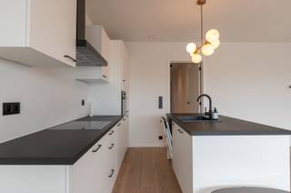<p>Zeer lichtrijk penthouse (EPC A) met 2 terrassen, vloerverwarming en ultieme privacy</p><p>Gelegen op de 6de (bovenste) verdieping van een recent nieuwbouwproject (2021) met slechts 1 appartement per verdieping. Dankzij de ligging boven de mooie bomenrij geniet je hier van volledige rust, geen inkijk en ultieme privacy.</p><p>Indeling &amp; Comfort:</p><p>- Leefruimte &amp; Keuken: Ruime, open leef- en eetruimte met een volledig uitgeruste keuken met eiland (voorzien van vaatwasser, koelkast, diepvriezer, keramische kookplaat en combi/microgolfoven).</p><p>- Terras vooraan: Gevelbreed, zuidgericht terras waar je het hele jaar door geniet van een prachtig uitzicht over de stad.</p><p>- Berging: Praktische technische ruimte met de cv-ketel, ventilatiesysteem D, omvormer voor de zonnepanelen en aansluiting voor een wasmachine.</p><p>- Badkamer: Moderne badkamer met inloopdouche en wastafelmeubel.</p><p>- Slaapkamer: Rustig gelegen slaapkamer met toegang tot een 2e terras met eveneens weids uitzicht.</p><p>Extra troeven:</p><p>- Vloerverwarming over het gehele appartement (inclusief slaapkamer).</p><p>- Zéér gunstig energieprofiel (EPC A) dankzij individuele zonnepanelen en hoogwaardige isolatie.</p><p>- Het gebouw beschikt over een personenlift, een handige fietsenlift naar de ondergrondse fietsenstalling en een privé kelderberging.</p>