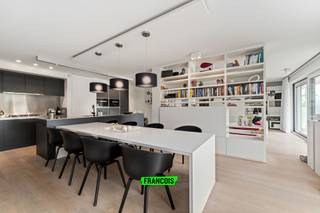 Dit uitzonderlijk ruim en luxueus appartement is gelegen in residentie Park Leopold II 1 te Wenduine op de eerste verdieping en op een rustige ligging net buiten het centrum. Dankzij de samenvoeging van twee appartementen geniet dit eigendom van een bijzonder royale bewoonbare oppervlakte van maar liefst 146 m². Bovendien werd voor de inrichting en afwerking samengewerkt met een architect, wat resulteert in een feilloos afgewerkt en modern geheel met een stijlvolle uitstraling.<br /><br />Bij het betreden van het appartement springt de hoogwaardige afwerking meteen in het oog. De ruime inkomhal, voorzien van praktische ingemaakte kasten, vormt de perfecte binnenkomer en biedt toegang tot de verschillende ruimtes van het appartement. Via een elegante deur bereikt men de leefruimte waar een organische overgang en het grote schuifraam zorgen voor een bijzonder open en lichtrijk gevoel.<br /><br />De woonkamer werd uiterst doordacht ingericht met een gezellige zithoek, een geïntegreerde bureauruimte en een centrale boekenkast die op subtiele wijze de scheiding vormt tussen de eetplaats en de leefruimte. De stijlvolle open keuken is uitgerust met alle moderne comfort en hoogwaardige toestellen. Eyecatcher van de ruimte is zonder twijfel de gezellige gashaard die extra sfeer creëert. Centraal in de keuken bevindt zich bovendien een praktische berging waar niet alleen extra opbergruimte voorzien werd, maar waar ook alle technische installaties van het appartement netjes gecentraliseerd zijn.<br /><br />Via de leefruimte bereikt men de eerste ruime slaapkamer, die beschikt over een ensuite badkamer met douche, lavabo en toilet. Aan de andere zijde van het appartement bevinden zich nog twee volwaardige slaapkamers, beide voorzien van ingemaakte kasten en met toegang tot het tweede terras van het appartement. Verder is er nog een tweede badkamer aanwezig, uitgerust met een inloopdouche en dubbele lavabo. In de inkomhal bevindt zich bovendien nog een apart gastentoilet.<br /><br />Het appartement beschikt over dubbele beglazing, individuele centrale verwarming op aardgas en conforme elektriciteit. Dankzij de gunstige EPC-score vormt dit appartement niet alleen een stijlvolle, maar ook energiezuinige woonoplossing.<br /><br />Ten slotte bevindt zich in de kelderverdieping ook een dubbele garage, verplicht aan te kopen voor 100.000 EUR. <br /><br />Kortom, een unieke kans voor wie op zoek is naar een luxueus afgewerkt appartement met royale volumes, veel lichtinval en een uitstekende ligging aan de Belgische kust. Ideaal als vaste woonplaats, tweede verblijf of investering. Plan nu uw bezoek in!<br /><br />