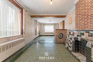 Voor meer info en foto’s, surf naar www.swevers.be – Op zoek naar een renovatieproject met veel potentieel? Deze halfopen woning in de Eliksemstraat 1 in Linter biedt een uitstekende basis om volledig naar eigen smaak te renoveren. De woning dateert van 1949 en beschikt over een bewoonbare oppervlakte van 146 m². Via de inkomhal bereikt u de ruime woonkamer van 32 m², aansluitend op de keuken van 20,5 m² met verbinding naar de badkamer. Achteraan bevinden zich een praktische berging en een overdekt terras. Op de eerste verdieping zijn er drie volwaardige slaapkamers van 15,64 m², 12,88 m² en 10 m². Daarnaast is er een extra kamer die perfect kan dienen als dressing, bureau of hobbyruimte. De woning beschikt bovendien over een kelder van 15 m² en een ruime zolder van 47,55 m², die tal van mogelijkheden biedt voor extra woon- of hobbyruimte, mits de nodige renovaties en volgens de geldende voorschriften. Het perceel van 147 m² is compact en onderhoudsvriendelijk. Dankzij het overdekte terras geniet u ook buiten van een rustige plek om te ontspannen. De woning ligt in een rustige straat met scholen op 300 meter, openbaar vervoer op 150 meter, winkels en horeca op 2,5 kilometer en een vlotte verbinding naar de snelwegen op ongeveer 7 kilometer. Een interessante opportuniteit voor wie een totaalrenovatie niet schuwt en op zoek is naar een woning met karakter, praktische indeling en toekomstpotentieel op een rustige locatie. Voor meer informatie, bel 012 699 900. Bron bewoonbare oppervlakte: EPC – verslag. Dit pand is onderworpen aan de renovatieverplichting van de Vlaamse overheid voor residentiële gebouwen (behoudens bij sloop binnen 5 jaar na de aankoop). Consulteer voor meer informatie de website van het Vlaams Energie- en Klimaatagentschap via https://www.vlaanderen.be/een-huis-of-appartement-kopen/renovatieverplichting-voor-residentiele-gebouwen.