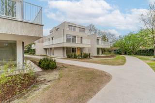 Centraal gelegen in de Leopoldstraat 18-20 te Rijkevorsel op een domein van ca. 5.600m² waarop thans de modernistische erfgoedvilla ‘De Patrijs’ reeds staat, werden bijkomend 2 urban villa’s gerealiseerd. <br /><br />Dit bijzonder villa appartement bevindt zich op de begane grond van Urban Villa B en biedt een uniek groen uitzicht en een uitzonderlijke privacy . De eigenaar beschikt over zowel een overdekt terras als een openlucht terras omgeven door de prachtig aangelegde parktuin.<br /><br />Dit uitzonderlijk appartement beschikt over 2 slaapkamers en is voorzien van een geothermische warmtepomp met vloerverwarming. De hoge graad van isolatie en de combinatie met individuele zonnepanelen maakt van deze woning een voorbeeld van energie zuinigheid.<br /><br />De afwerking werd zorgvuldig en hoogwaardig gekozen met o.a. een moderne ingerichte keuken met kook eiland afgewerkt met composiet en toestellen van AEG.<br />Een plafondhoge steellook deur tussen woonkamer en gang zorgt voor een mooi detail en de uitzonderlijke hoge deuren van maar liefst 2.35m gecombineerd met de hoge plafonds van 2.7m zorgen voor een extra gevoel van ruimte.<br /><br />Veel lichtinval wordt gegarandeerd door de vele kamerhoge ramen. De berging naast de keuken is bijzonder ruim.<br />Het appartement is zeer snel beschikbaar voor zij die bv van een woning naar een appartement wensen te verhuizen. Tevens als belegging een goede keuze.<br /><br />In de ondergrondse garage is er een grote fietsenstalling inbegrepen in de prijs. De ondergrondse parkeerplaats is verplicht bij aan te kopen.<br />6% BTW mogelijk onder voorwaarden.<br /><br />‘Het project is rustig gelegen, recht tegenover de basisschool en op een boogscheut van het gemeentehuis en het dorpsplein.’<br />Hierdoor zal u in ‘Parkdomein De Patrijs’ in alle stilte en rust komen wonen.<br /><br /><span><strong>Voor een bezoek ter plaatse kan U vrijblijvend een afspraak maken op kantoor.</strong></span>