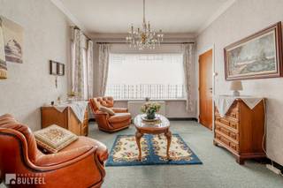 In een rustige straat doch op wandelafstand van het centrum bevindt zich deze ruime te renoveren woning. De woning biedt u op het gelijkvloers een inkomhal, een lichtrijke living, een spender, een keuken, een wasplaats/berging en een apart toilet. Op de eerste verdieping zijn er 3 slaapkamers waarvan 2 grote en 1 kleinere en een badkamer met lavabo en bad/douche. De ruime zolder is te bereiken via een schuiftrap maar kan in de toekomst perfect ingericht worden naar eigen smaak. Achter de woning bevinden zich nog twee ruime garages en een extra bergruimte, die eveneens dienst kunnen doen als opslagruimte.. Naast de woning is er plaats voor meerdere wagens. De ramen zijn voorzien van dubbele beglazing en rolluiken. Elektrische verwarming. Airco units aanwezig in de living en slaapkamer. In de directe omgeving van winkels, openbaar vervoer en school. Goede verbinding naar N16 en E17. Kortom, een ideale aankoop voor wie graag de handen uit de mouwen steekt.