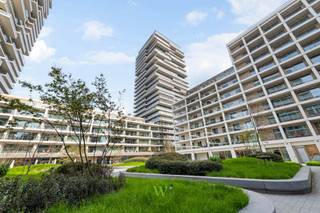Zee, jachthaven, de torens van de Sint-Petrus en Sint-Pauluskerk — het panorama vanuit dit hoekappartement op de negende verdieping van Sky Tower 2 laat niemand onbewogen. Dag na dag een ander schouwspel. Elke blik naar buiten zorgt voor een grenzeloze verwondering.<br /><br />De 103 m² bieden ruimte zonder compromis. Een royale inkomhal met apart gastentoilet geeft toegang tot de lichtrijke leefruimte met open keuken, omsloten door floor-to-ceiling glasgevels aan twee zijden. Zon stroomt binnen van de middag tot de avond, en met het 39 m² terras vervagen de grenzen tussen binnen en buiten volledig. Aan weerszijden van de leefruimte bevindt zich een volwaardige 2-persoonsslaapkamer, elk met een eigen privébadkamer.<br /><br />De afwerking is luxueus met hoogkwalitatieve materialen: parket in de leefzones, solide vloeren en tegels in keuken en badkamers, vloerverwarming op afstand bedienbaar met aansluiting op het warmtenet. Comfort en duurzaamheid als evidentie. Het gebouw beschikt bovendien over een fietsenstalling en huisvuillokaal.<br /><br />Door te wonen op hoogte ervaar je de rust van het grenzeloos uitzicht enerzijds én de energie van de bruisende stad anderzijds — kortom, eindeloze verwondering.<br /><br />De voorgestelde prijs is excl. 21%btw. De foto's met meubilair zijn visualisaties ter illustratie.<br /><br />Er zijn geen maatregelen gevonden op dit kadastraal perceel volgens onze opvraging bij het Maatregelenregister. <br /><br />Interesse in dit TOP-appartement?<br />Contacteer Katrien via 0477 46 53 11 of via e-mail: katrien@waeyler.be.