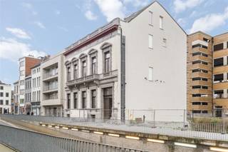 Gelegen in het hart van Kortrijk, biedt dit indrukwekkende kantoorpand een royale bruikbare oppervlakte van 456,7 m². Het historische karakter van het gebouw wordt op elegante wijze gecombineerd met moderne functionaliteiten, waardoor het een ideale werkplek is.Bij binnenkomst valt meteen de ruime en goed verlichte receptie op, perfect om gasten te ontvangen. De majestueuze houten trappen geven het interieur een klassieke uitstraling en leiden naar verschillende kantoorruimtes. Deze ruimtes zijn voorzien van hoge plafonds en grote ramen, wat zorgt voor een aangename en lichte werksfeer.Het pand beschikt over meerdere stijlvolle vergaderruimtes, elk met een uniek karakter. De parketvloeren en verfijnde afwerking benadrukken de kwaliteit en klasse van het gebouw. Daarnaast zijn er voldoende sanitaire voorzieningen aanwezig voor het comfort van uw team en bezoekers.Dankzij zijn centrale ligging in Kortrijk is het pand uitstekend bereikbaar, zowel met de auto als met het openbaar vervoer. Diverse parkeermogelijkheden in de nabijheid maken het extra toegankelijk.Dit pand is de perfecte keuze voor bedrijven die op zoek zijn naar een prestigieuze locatie met een authentieke uitstraling. Mis deze unieke kans niet om uw bedrijf naar een hoger niveau te tillen in een van de meest opmerkelijke kantoorgebouwen van Kortrijk.