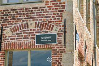 Langs de Potterierei, in het historisch hart van Brugge, bevindt zich dit te renoveren herenhuis, voormalig dokterswoning, met een uitzonderlijke combinatie van karakter, ruimte en ligging. Het prachtige zicht op het water, de authentieke elementen en de royale volumes maken van deze eigendom een zeldzame opportuniteit binnen de Brugse binnenstad.<br /><br />De woning beschikt over hoge plafonds, een authentieke inkomhal met statige trap, ruime leef- en eetruimtes en een gunstig georiënteerde stadstuin waar in alle rust van het buitenleven kan worden genoten. Op het gelijkvloers bevinden zich daarnaast een polyvalente ruimte die perfect kan dienen als praktijk, bureau of salon, een keuken en een inpandige garage.<br /><br />Op de eerste verdieping bevinden zich vier ruime kamers met sanitaire voorzieningen. De tweede verdieping omvat een ruime zolder en een studio, waardoor deze eigendom tal van mogelijkheden biedt voor wie op zoek is naar een karaktervolle stadswoning met potentieel.