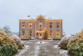 In een rustige straat, grenzend aan natuurgebied en aan de Kempense Golfclub, treffen we deze exclusieve villa met o.a. 3 slaapkamers, 3 badkamers en groot bijgebouw met 2 slaapkamers en badkamer op een ruim perceel van 10.728 m².<br /><br />Indeling gelijkvloers:<br />Bij het binnenkomen wordt u op het gelijkvloers verwelkomd in een ruime inkomhal met prachtige trap. Vanuit de inkomhal heeft u toegang tot het woongedeelte en de kantoorruimte dewelke aan de voorzijde van de villa terug te vinden zijn. In de leefruimte kan u volledig tot rust komen en vertoeven aan de prachtige Franse open haard. Deze ruimte kan perfect opgedeeld worden in een zithoek en eethoek. Vanuit alle leefruimtes heeft u een panoramisch uitzicht over de aangelegde tuin en de achterliggende velden.<br /><br />De keuken bevindt zich aan de achterzijde en is uitgerust met een kookplaat, afzuigkap, vaatwasser, koelkast, oven, microgolfoven en voldoende opbergruimte. Aangrenzend vindt u een gezellige zithoek, centraal gelegen tussen de woonkamer en de keuken, dewelke eveneens een prachtig zicht heeft over de aangelegde tuin. <br /><br />Daarnaast is er een ruime en praktische wasplaats, evenals een badkamer met douche, toilet en wastafel.<br /><br />Eerste verdieping:<br />De eerste verdieping is bereikbaar via de imposante trap of via de lift. De nachthal biedt toegang tot een apart toilet, twee slaapkamers, een extra badkamer met ligbad, douche en dubbele wastafel en een leefruimte met kitchenette. Vanuit deze leefruimte is er toegang naar een derde slaapkamer met ensuite badkamer (douche, toilet). Elke slaapkamer is ruim voorzien van ingebouwde kasten.<br /><br />Tweede verdieping:<br />Via de lift bereikt u de zolderruimte, die nog naar wens kan afgewerkt worden. Deze ruimte biedt de mogelijkheid om omgevormd te worden tot een ruime studio, hobbyruimte of extra slaapkamers.<br /><br />Bijgebouwen en tuin:<br />In de tuin treffen we het mooie bijgebouw bestaande uit een inpandige garage met plaats voor twee wagens en een volledige woongelegenheid. De woongelegenheid omvat een leefruimte, keuken, gastentoilet, twee slaapkamers, badkamer (douche, wastafel) en zolderruimte. Verder is er nog een gemetseld tuinhuis op het perceel aanwezig.<br /><br />Buitengewone kenmerken:<br />* Karaktervolle woning<br />* Veel natuurlijke lichtinval<br />* Mogelijkheid om meerdere slaapkamers te creëren<br />* Ingebouwde kasten<br />* Groot en breed perceel<br />* Rustige ligging nabij de Kempense Golfclub