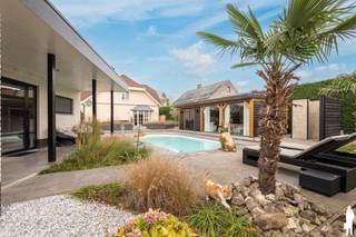 <p><strong><em>Unieke eigendom met luxevilla én hoogwaardige praktijkruimte/bijgebouw (±120 m²) </em></strong></p>
<p><em>Bent u op zoek naar de perfecte combinatie van wonen en werken? Deze uitzonderlijke eigendom, gelegen op een rustig hoekperceel van 1.353 m² nabij de Nederlandse grens, biedt een instapklare villa én een recent gebouwd, volledig uitgerust bijgebouw van ca. 120 m² – ideaal als praktijkruimte, beautysalon, kantoor of B&B.</em></p>
<p><strong><em>Beautysalong staat g achter die moet weg </em></strong></p>
<p><em>Het moderne volledig vergund bijgebouw (bouwjaar 2020) is momenteel ingericht als beautysalon en vormt een volwaardige, professionele werkruimte aan huis. Dankzij de doordachte indeling en hoogwaardige afwerking is dit gebouw perfect geschikt voor diverse doeleinden zoals een praktijk, kantoor, gastenverblijf of B&B.</em></p>
<ol>
<li><em>Oppervlakte ca. 120 m²</em></li>
<li><em>Ingedeeld in ontvangstruimte met 2 behandelkamers waarvan 1 voorzien van douche en aparte toilet</em></li>
<li><em>Ruime inpandige garage met automatische poort</em></li>
<li><em>Aansluitingen voor wasmachine en droogkast</em></li>
<li><em>Vloerverwarming als hoofdverwarming</em></li>
<li><em>Eigen cv-installatie</em></li>
<li><em>Uitstekende mogelijkheden voor zelfstandige activiteit of verhuur</em></li>
<li><em> </em></li>
</ol>
<p><em>Een unieke kans voor wie wonen en werken moeiteloos wil combineren, met behoud van privacy en comfort.</em></p>
<p><strong><em> </em></strong></p>
<p><strong><em>De villa</em></strong></p>
<p><em>De instapklare villa biedt ruime en lichtrijke leefruimtes. U betreedt de woning via de inkomhal met gastentoilet. De gezellige woonkamer met erker, gashaard en veel natuurlijk licht geeft rechtstreeks toegang tot de tuin. Aansluitend bevindt zich de ruime leefkeuken met kookeiland en kwalitatieve inbouwtoestellen.</em></p>
<p><em>Verder beschikt het gelijkvloers over een bureau of extra slaapkamer en een praktische (wijn) kelder (ca. 20 m²). De benedenverdieping is grotendeels voorzien van vloerverwarming.</em></p>
<p><em>Op de eerste verdieping vindt u vier slaapkamers. De master bedroom beschikt over een dressing en een luxueuze en-suite badkamer. Daarnaast is er een tweede badkamer en een ruime bergzolder.</em></p>
<p><em>De zuidgerichte tuin is prachtig aangelegd en biedt alles voor ontspanning:</em></p>
<ol>
<li><em>Verwarmd Starline zwembad met buitendouche</em></li>
<li><em>Overdekte relaxruimte (±32 m²) met jacuzzi en glazen schuifpanelen</em></li>
<li><em>Meerdere terrassen</em></li>
<li><em>Parkeergelegenheid voor 6 wagens + laadpaal</em></li>
</ol>
<p><strong><em>Bijzonderheden:</em></strong></p>
<p><strong><em> </em></strong></p>
<ol>
<li><em>EPC-label B (woning) en A (bijgebouw)</em></li>
<li><em>30 zonnepanelen</em></li>
<li><em>Aluminium ramen, rolluiken en markiezen</em></li>
<li><em>Woning (2001) volledig gemoderniseerd in 2020</em></li>
<li><em>Bewoonbare opp. woning ca. 300 m²</em></li>
<li><em>Uitgebreid alarm- en camerasysteem</em></li>
<li><em>Elektriciteit conform</em></li>
</ol>
<p><em> </em></p>
<p><strong><em>Kortom:</em></strong><em> een instapklare totaaloplossing voor wie comfortabel wil wonen én professioneel wil werken op één locatie, met een instapklaar bijgebouw dat meteen rendeert.</em></p>