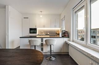 Welkom in dit stijlvol en tot in de puntjes vernieuwde appartement, gelegen op de tweede én bovenste verdieping van een kleinschalig gebouw. Dankzij die ligging geniet je hier van maximale rust en privacy, zonder bovenburen en met een groen uitzicht dat meteen voor ontspanning zorgt.<br /><br />Het appartement wordt momenteel verhuurd aan een betrouwbare huurder met een maandelijkse huurprijs van €1.050, wat zorgt voor een onmiddellijk rendement voor investeerders.<br /><br />De indeling is als volgt: een ruime inkomhal die uitkomt op de lichtrijke leefruimte van maar liefst 43 m², met een open en moderne keuken waar koken en leven perfect samenvloeien. De twee slaapkamers (13,5 m² en 10 m²) zijn volwaardig en rustig gelegen. De badkamer is uitgerust met een stijlvolle inloopdouche en lavabomeubel. Daarnaast is er een apart gastentoilet en een praktische berging.<br /><br />Het zuidgericht terras nodigt uit tot gezellige buiten momenten. En parkeren? Dat doe je zorgeloos in de garagebox, verplicht bij aan te kopen €25.000.<br /><br />De maandelijkse provisie bedraagt €184 (incl. gem. kosten, syndicus, poetsdienst, verwarming en water). Elektriciteit is via een individuele meter.<br /><br />Benieuwd om dit appartement te ontdekken? We plannen met plezier een bezoek in, contacteer Neon Vastgoed via 03/336.88.88 of mail naar info@neonvastgoed.be.