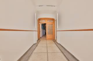 <p>Een stijlvolle <strong>burgerwoning van maar liefst 357 m²</strong>, doordrenkt met authenticiteit, licht en ruimte. En dat allemaal achter die knappe gevel die meteen de toon zet.</p>
<p>Via de prachtige inkomdeur stap je de royale hal in op originele terrazzo vloer, waar het warme houtwerk en de hoge plafonds je welkom heten. Aan de rechterkant bevindt zich een verrassend ruime bureau- of hobbykamer, ideaal voor wie thuis werkt of creatief uit de hoek komt. Achteraan ligt een groot atelier/opslagruimte, perfect voor makers, verzamelaars of professionals die hun werkruimte onder hetzelfde dak willen.</p>
<p>De brede trap brengt je naar de eerste verdieping waar het echte woongedeelte zich ontvouwt.<br />Een lichtrijke leefruimte met hoge plafonds, originele houten vloeren en sfeer in elke hoek.<br />De keuken, modern maar met karakter, brengt licht binnen langs elke kant en sluit heerlijk aan op het terras.</p>
<p>De tweede verdieping herbergt 2 royale slaapkamers en een stijlvolle badkamer met een ruim ligbad, dubbele lavabo, zachte kleuren en een rustgevende sfeer. De perfecte ruimte om je dag te starten of af te sluiten! Minder ontspannend maar wel o-zo-handig is de berging voor wasmachine en droogruimte, perfect geïntegreerd in de badkamer. En alsof het niet op kan, is hier aanpalend nog een extra terras (<em>niet vergund)</em>.</p>
<p>En dan, bovenaan: een volledig afgewerkte <strong>studio</strong> met eigen leefruimte, keuken en badkamer. Perfect voor een inwonende student, een au-pair, een extra bron van inkomsten of gewoon je eigen creatieve cocon.</p>
<p>Doorheen de woning zie je hoe zorgvuldig alles werd gerenoveerd in 2004: originele elementen behouden, karakter gerespecteerd, maar toch klaar voor vandaag.</p>
<p><strong>Troeven in één oogopslag:<br /></strong>- Prachtige burgerwoning met uitstraling<br />- Groot atelier/opslag op het gelijkvloers<br />- Woning + aparte studio voor gasten, werk of verhuur<br />- Volledig gerenoveerd (2004) met kwalitatieve materialen en behoud van originele elementen<br />- Royale leefruimtes en veel natuurlijk licht<br />- Ideaal voor wonen + werken of co-house<br />- Ruim, origineel, karaktervol<br /><br />Kom je dit knappe geheel zelf ontdekken? Plan een afspraak in, we tonen het met plezier.<br /><br />Wg, Gvkr, Gvv, Gmo, Geen overstromingsgevoelig gebied</p>