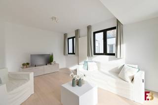 Op zoek naar een instapklaar appartement met tuin, rustig gelegen en toch vlak bij alle voorzieningen? Dan is dit gelijkvloersappartement in een kleine residentie zonder syndicus en zonder lift precies wat je zoekt!<br /><br />Bij het binnenkomen valt meteen de aangename indeling op. De inkomhal met apart toilet geeft toegang tot de zeer grote hoofdslaapkamer en een tweede slaapkamer, ideaal als logeerkamer, bureau of kinderkamer. Verder is er een praktische technische ruimte en een aparte berging.<br /><br />De badkamer is stijlvol afgewerkt met een inloopdouche en dubbele lavabo in meubel. Achteraan bevindt zich de lichtrijke leefruimte met open, volledig geïnstalleerde keuken, met uitzicht op het ruime terras en de aangename tuin. Dankzij het poortje achteraan is de tuin ook langs achter toegankelijk — handig voor fietsen of tuinmateriaal.<br /><br />Bij het appartement horen twee garages, die verplicht mee aan te kopen zijn - €50.000 voor de twee. Beide garages beschikken over elektriciteit en verlichting, en aangezien het de laatste twee garages in de rij zijn, bieden ze bovendien nog twee extra parkeerplaatsen. Ook hier is elektriciteit voorzien voor het monofasig opladen van een wagen.<br /><br />Qua ligging zit je hier helemaal goed: op slechts enkele minuten van de R4 en de op- en afrit van de E17, en met een tramhalte op amper 300 meter. Zo ben je in geen tijd in het centrum van Gent of op weg richting autosnelweg.<br /><br />Een rustig gelegen, energiezuinige appartement met alle comfort en een praktische indeling — ideaal voor wie op zoek is naar het gemak van een appartement, maar toch wil genieten van een tuin!