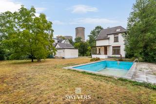 Voor meer info en foto’s, surf naar www.swevers.be – Aan de Koolmijnlaan 190 in Koersel vindt u deze karaktervolle vrijstaande herenwoning uit 1918. Met 331 m² bewoonbare oppervlakte, hoge plafonds, authentieke elementen en royale ruimtes biedt deze te renoveren woning bijzonder veel potentieel. De gelijkvloerse verdieping omvat een centrale inkomhal, woonkamer met erker, afzonderlijke leef- en eetruimte, keuken, tweede hal, toilet en berging. De bestaande indeling biedt volop mogelijkheden om de woning tijdens de renovatie aan te passen aan een hedendaagse woonstijl. Op de eerste verdieping bevinden zich vier ruime slaapkamers en een badkamer. De tweede verdieping telt nog drie slaapkamers, waardoor de woning in totaal zeven ruime slaapkamers biedt. Ideaal voor een groot gezin, thuiswerk of hobby- en logeerruimtes. Daarnaast is er een ruime kelder van circa 85 m². Via de oprit bereikt u twee grote garages. Achteraan ligt een royale, zuidwest georiënteerde tuin met zwembad op een perceel van bijna 20 are. Verder zijn onder meer zonnepanelen, elektrische rolluiken en een alarmsysteem aanwezig. Scholen, openbaar vervoer en restaurants liggen vlakbij. Ook winkels, ontspanning, de snelweg en be-MINE zijn vlot bereikbaar. Een unieke kans voor wie karakter, ruimte en renovatiepotentieel wil combineren. Voor meer informatie, bel 011 255 155. Bron bewoonbare oppervlakte: EPC – verslag. Dit pand is onderworpen aan de renovatieverplichting van de Vlaamse overheid voor residentiële gebouwen (behoudens bij sloop binnen 5 jaar na de aankoop). Consulteer voor meer informatie de website van het Vlaams Energie- en Klimaatagentschap via https://www.vlaanderen.be/een-huis-of-appartement-kopen/renovatieverplichting-voor-residentiele-gebouwen.