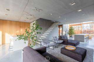 Deze eigendom is gewoonweg een parel in zijn soort en scoort hoog op <strong>woonbeleving door zijn concept</strong>, de open ruimteperspectieven en gebruik van <strong>beton op zijn best in combinatie met warme houttinten</strong>. De woning heeft tegelijk een <strong>brutalistisch en minimalistisch karakter</strong>. Betonnen prefab elementen geven aan de binnenkant van het huis prachtige kleurschakeringen. Het huis werd bewust met tijdloze en sobere materialen gebouwd waardoor ook eventuele designobjecten mooi tot hun recht kunnen komen.<br /><br />Je komt de woning binnen via een inkomhal met afzonderlijk toilet en toegang tot de berging. Dit afzonderlijk toilet kan zowel gebruikt worden via de inkomhal als de praktijkruimte.<br />Vanuit de inkom kom je in de woonkamer waar licht en ruimte de tuin laten binnenkomen.<br />De eetkamer en keuken staan in verbinding met het ruime terras en de tuin. Op het gelijkvloers is een <strong>ruime praktijkruimte van +/-50m²</strong> dat kan ingezet worden als kantoor, kinesistenpraktijk of polyvalente ruimte. Op de eerste verdieping is een bureauruimte met een heel fijn zicht op de voortuin en de benedenverdieping, twee slaapkamers, een ruime wasplaats, een badkamer (met ligbad, douche en toilet). Op de tweede verdieping is een zolderruimte, technische ruimte, een bijkomende derde slaapkamer en een ruime zolderkamer die eveneens kan ingericht worden naar eigen wensen.<br /><br />Bijkomende troeven:<br />- <strong>EPC label A ! </strong><br />- voldoende parkeerplaats<br />- architecturaal interessante woning<br />- multifunctioneel karakter en inzetbaarheid gezien uitzonderlijke praktijkruimte<br /><br />Aarzel niet om een bezoek aan te vragen via vastgoed@claves.be of het nummer 03/5029874<br /><br /> 