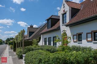Inkom met gastentoilet en vestiaire, ruime living met parket, open haard en ingebouwkasten, eetkamer met parket, luxueus ingerichte keuken met...