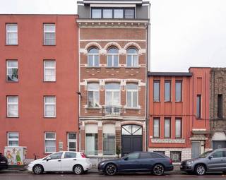 <p>Welkom in de Tweemontstraat. Van buiten zie je een statige gevel. Binnenin ontdek je 296m2 aan mogelijkheden!</p>
<p>De eerste deur die je tegenkomt? Die leidt naar een royale bureauruimte.<br />Vandaag een stijlvolle thuiswerkplek. Morgen misschien een creatieve studio of een speelkamer?<br />Nog enkele stappen verder kom je aan in de mooie, gezellige zithoek met gashaard.<br />Een zee van licht stroomt binnen via de grote ramen, en de zithoek lijkt bijna ongemerkt over te lopen in de zonnige tuin.<br />En dan zie je het. Het charmante koetshuis.<br />Een gebouw waar je automatisch naartoe wandelt. Vandaag ingericht als atelier. Maar eerlijk? Iedereen zal er iets anders in zien: een kantoor, een hobbyruimte, een plek voor logerende vrienden. Of gewoon dat ene toevluchtsoord waar je eindelijk ongestoord een boek kan uitlezen.<br />Dat is misschien wel het mooiste eraan: het geeft mogelijkheden. En mogelijkheden vervelen nooit...<br /><br />We nemen de trap naar boven en ook hier blijft de woning verrassen.<br />De keuken is geen ruimte die ergens achteraan werd weggestopt.<br />Integendeel. Ze krijgt de plaats die ze verdient. Modern, strak en afgewerkt in inox.<br />Met een royaal kookeiland waar ontbijten, aperitieven en uitgebreid koken vlot in elkaar overlopen.<br />Terwijl jij staat te koken, kijk je uit op het groene dak.<br />Aan de straatzijde ligt de eetkamer. Een ruimte waar je zonder moeite een lange tafel kwijt kan.<br /><br />Nog een verdieping hoger.<br />En hier voelt het alsof je een boetiekhotel binnenstapt.<br />De master bedroom straalt rust uit. En aansluitend is er de uitnodigende luxueuze badkamer. Een vrijstaand ligbad, een ruime inloopdouche en een dubbele lavabo.<br />Helemaal boven wachten nog twee volwaardige slaapkamers en een extra badkamer. Geen ochtendfiles aan de badkamerdeur. Dat alleen al is soms goud waard.<br /><br />Achter de charme schuilt bovendien een woning die helemaal mee is met haar tijd.<br />Met een EPC B, conforme elektriciteit, zonnepanelen, airconditioning, teleruptoren en een droge kelder zijn ook de technische fundamenten helemaal op orde.</p>
<p>Troeven:<br />- 296 m² bew. opp.<br />- Volledig gerenoveerd<br />- EPC B<br />- AREI conform<br />- Zonnepanelen<br />- Airconditioning<br />- Mooie bureauruimte<br />- Lichtrijke leefruimte met grote glaspartijen<br />- Prachtig koetshuis met tal van mogelijkheden<br />- Moderne RVS-keuken met kookeiland<br />- Luxueuze master met ensuite badkamer<br />- Tweede badkamer<br />- Zonnige stadstuin<br />- Groendak<br />- Droge kelder<br />- Teleruptoren</p>