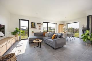 <strong>GELIJKVLOERS</strong><br />Inkomhal (aparte toegang) met vestiaireruimte. Nachthal. Woonkamer met grote raampartijen en toegang tot het terras. <br />Open keuken met keukeneiland en composieten werkblad voorzien van de volgende toestellen nl. heteluchtoven, microgolfoven, inductiekookplaat met geïntegreerde afzuiging, spoeltafel, vaatwasmachine en koelkast. <br />Aansluitende berging met aardgasbrander van de C.V. en warmwater, omvormer van de zonnepanelen en zekeringenkast.<br />2 slaapkamers voorzien van een airco-aansluiting. Toiletruimte met lavabo. Badkamer met ingemaakte kasten en aansluiting voor wasmachine/droogkast (condensatie), inloopdouche en badkamermeubel met dubbele lavabo. <br /><br /><strong>BUITEN</strong><br />Zuidgeoriënteerd terras en gemeenschappelijke tuin. <br /><br /><strong>KELDERVERDIEPING</strong><br />3 autostaanplaatsen die optioneel aangekocht kunnen worden aan 18.000 Euro/parkeerplaats en waarvan één omgevormd is tot bergruimte.<br />Gemeenschappelijke fietsenberging en afvalruimte. <br /><br /><strong>BIJZONDERHEDEN</strong> <br />Aluminium ramen. Dubbele hoogrendementsbeglazing. Vliegenhorren. Vloerverwarming. 6 zonnepanelen. Regenwateraansluiting op toilet. <br /><br /><strong>POSITIEVE ASPECTEN</strong><br />Gelegen op fietsafstand van alle nodige voorzieningen<br />Gelijkvloers appartement van 105m²<br />EPC label A (E-peil 19)<br />Voldoende parkeergelegenheid <br />Kleinschalig appartementsgebouw bestaande uit 12 eenheden