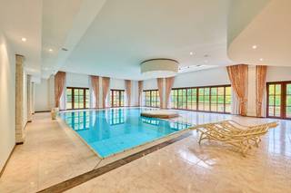 Ontdek deze uitzonderlijke villa die niet alleen uitblinkt door haar royale afmetingen en luxueuze afwerking, maar vooral door haar uitstekende ligging. Gelegen in een prestigieuze, residentiële wijk biedt deze eigendom het beste van twee werelden: een oase van rust en privacy in een groene omgeving, én een uitstekende bereikbaarheid. Binnen slechts enkele minuten bereikt u de E314, Maasmechelen Village en het Nationaal Park Hoge Kempen – ideaal voor wie houdt van natuur, wandelen, shoppen en genieten van het leven.<br />De villa ligt op een prachtig, volledig omheind perceel van 67a 09ca met een parkachtige tuin, perfect onderhouden en zuidgericht. <br />Bovendien beschikt deze eigendom over twee afzonderlijke, zeer ruime garages, ideaal voor meerdere wagens, hobbyvoertuigen of extra opslagruimte.<br /><br />Een absolute troef is de bijna 200 m² grote kelderverdieping, die ingericht is als volwaardige extra leeflaag met onder meer een wijnkelder, een multifunctionele verblijfsruimte, een praktische wasruimte en een ruime provisiekamer.<br /><br />Dankzij het eigen tennisveld, de uitgebreide wellnessruimte met binnenzwembad, jacuzzi en sauna, en de ruime leefruimtes, vormt deze woning een unieke combinatie van elegantie, ontspanning en wooncomfort.<br />De woning is met oog voor detail afgewerkt met hoogwaardige materialen en biedt een warme, uitnodigende sfeer.<br /><br />________________________________________<br />Indeling:<br /><br />Gelijkvloers<br />•    Inkomhal met imposante massieve eiken trap<br />•    Gastentoilet <br />•    Royale woonkamer met open haard en veel lichtinval<br />•    Volledig uitgeruste keuken met hoogwaardige toestellen en ruime opbergmogelijkheden<br />•    Bureel / thuiskantoor<br />•    Drie slaapkamers<br />•    Drie badkamers<br />•    Luxe wellnessruimte met binnenzwembad, jacuzzi, sauna en douche<br /><br />Verdieping<br />•    Overloop met gezellige zitruimte<br />•    Twee slaapkamers<br />•    Badkamer met jacuzzi, dubbel lavabomeubel en toilet<br />•    Hobbykamer / multifunctionele ruimte, ideaal als fitnessruimte of speelkamer<br /><br />Kelderverdieping (ca. 200 m²)<br />• Wijnkelder<br />• Multifunctionele verblijfsruimte (ideaal als lounge, hobbyruimte)<br />• Wasruimte<br />• Ruime provisiekamer / berging<br /><br />Garages<br />• Twee afzonderlijke, ruime garages met plaats voor meerdere voertuigen en extra opslag<br /><br />Tuin<br />• Schitterende, zuidgerichte en volledig aangelegde tuin<br />• Eigen tennisveld<br />• Volledige omheining voor maximale privacy en veiligheid<br /><br /><br />Technisch:<br />• Bouwjaar: 1989<br />• EPC: F (527 kWh/m²jaar) - (UC 20210609-0002426706-RES-1)<br />• Renovatieplicht: ja<br />• Elektriciteit: conform<br />• Mazouttank: 5000 l<br />• Asbestattest: asbestveilig<br />• Vg, Wg, Gmo, Gvkr, Gvv<br />• Watertoets: P-score: A ; G-score: A<br />• Niet gelegen in watergevoelig openruimtegebied<br />• Maatregelenregister : Er zijn geen maatregelen op dit perceel<br /><br />Samenvattend:<br />Deze villa is een uitzonderlijke eigendom voor wie houdt van ruimte, rust en verfijning op een absolute toplocatie, en straalt nog steeds dezelfde tijdloze klasse en royale charme uit. Dankzij de combinatie van privacy, luxe en uitstekende verbindingen vormt dit een unieke kans voor wie op zoek is naar een karaktervolle woning met potentieel op een toplocatie. Wilt u deze bijzondere villa met eigen ogen ontdekken? Neem gerust contact met ons op voor een exclusieve bezichtiging.