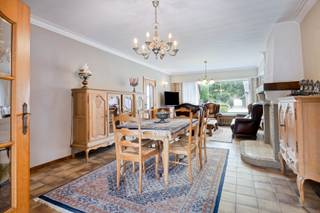 Deze woning is gunstig, maar toch rustig en landelijk gelegen, op fietsafstand van het centrum van Arendonk. Dankzij de centrale ligging geniet je van een vlotte verbinding naar de omliggende gemeenten en de autosnelweg E34 Antwerpen-Eindhoven.<br /><br />Via de inkomhal met vestiaireruimte kom je in de ruime leefruimte, die is opgedeeld in een gezellige zithoek en een eethoek. Centraal bevindt zich een schouw waar perfect een haard kan worden geplaatst voor extra sfeer tijdens de koude maanden. De leefkeuken bestaat uit een aanbouwkeuken, uitgerust met een koelkast, keramische kookplaat, afzuigkap, vaatwasser, combi-oven, wastafel, granieten werkbladen en voldoende kastruimte. Er is bovendien plaats voor een ontbijt- of eethoek én een extra zithoek. Dankzij de vele ramen geniet je in alle leefruimtes van een aangename lichtinval en een mooi uitzicht op de tuin en het achterliggende groen. Een dubbel schuifraam geeft rechtstreeks toegang tot het terras.<br /><br />De volledig betegelde wasplaats is voorzien van een extra douche. De berging en de droge kelder zorgen voor extra opbergruimte. De garage beschikt over een automatische sectionaalpoort. Via de achterinkom bereik je het gastentoilet met wastafel en een praktische inbouwkast.<br /><br />Op de verdieping geeft de nachthal toegang tot vier slaapkamers, waarvan twee zijn uitgerust met inbouwkasten. De badkamer beschikt over een ligbad, een wastafel en een tweede toilet. Via een luik met uitschuiftrap op de nachthal bereik je de zolder, die ideaal is als extra bergruimte.<br /><br />De zuidgeoriënteerde tuin beschikt over een terras, een overdekt terras en een bijgebouw met tuinhuis. Dankzij de ruime opzet is de tuin ideaal voor kinderen en huisdieren.<br /><br />De woning werd degelijk gebouwd en steeds uitstekend onderhouden. Bovendien zijn nagenoeg overal (deels elektrische) rolluiken voorzien.<br /><br />Ben je op zoek naar een ruime woning met vier slaapkamers op een rustige, maar tegelijk centrale locatie? Dan is deze woning zeker een bezoek waard.