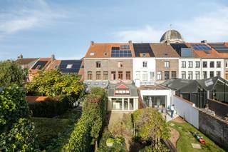 In de Carmersstraat te Brugge vindt u deze charmante herenwoning, gedeeltelijk gerenoveerd in 2023, gelegen in het gegeerde Sint-Annakwartier te Brugge, op wandelafstand van het centrum.<br /><br />De woning beschikt over een imposante inkomhal, lichtrijke leefruimte, volledig geïnstalleerde keuken, aparte bureauruimte, vier slaapkamers, een ruime badkamer met inloopdouche, dubbele wastafel en toilet, alsook een praktische wasplaats en extra bergruimte.<br /><br />Vanuit de keuken heeft u toegang tot de gezellige stadstuin met aansluitend een dubbele garage en uitweg langs de Rolweg. Daarnaast is de woning uitgerust met 10 zonnepanelen en geniet ze van een uiterst gunstig EPC.<br /><br />Indeling (263m²):<br /><br />Gelijkvloers:<br />- Inkomhal<br />- Bureauruimte<br />- Gastentoilet<br />- Woonkamer<br />- Open keuken met toegang tot de<br />stadstuin<br />- Stadstuin (110m²)<br /><br />Eerste verdieping:<br />- Slaapkamer<br />- Slaapkamer / wasruimte<br />- Badkamer<br /><br />Tweede verdieping:<br />- Slaapkamer<br />- Slaapkamer<br /><br />Ruime praktische zolder<br /><br />Dubbele garagebox<br /><br />Interesse? Aarzel niet om contact met ons op te nemen.<br /><br />Bestuursmaatregelen in het maatregelenregister: nee